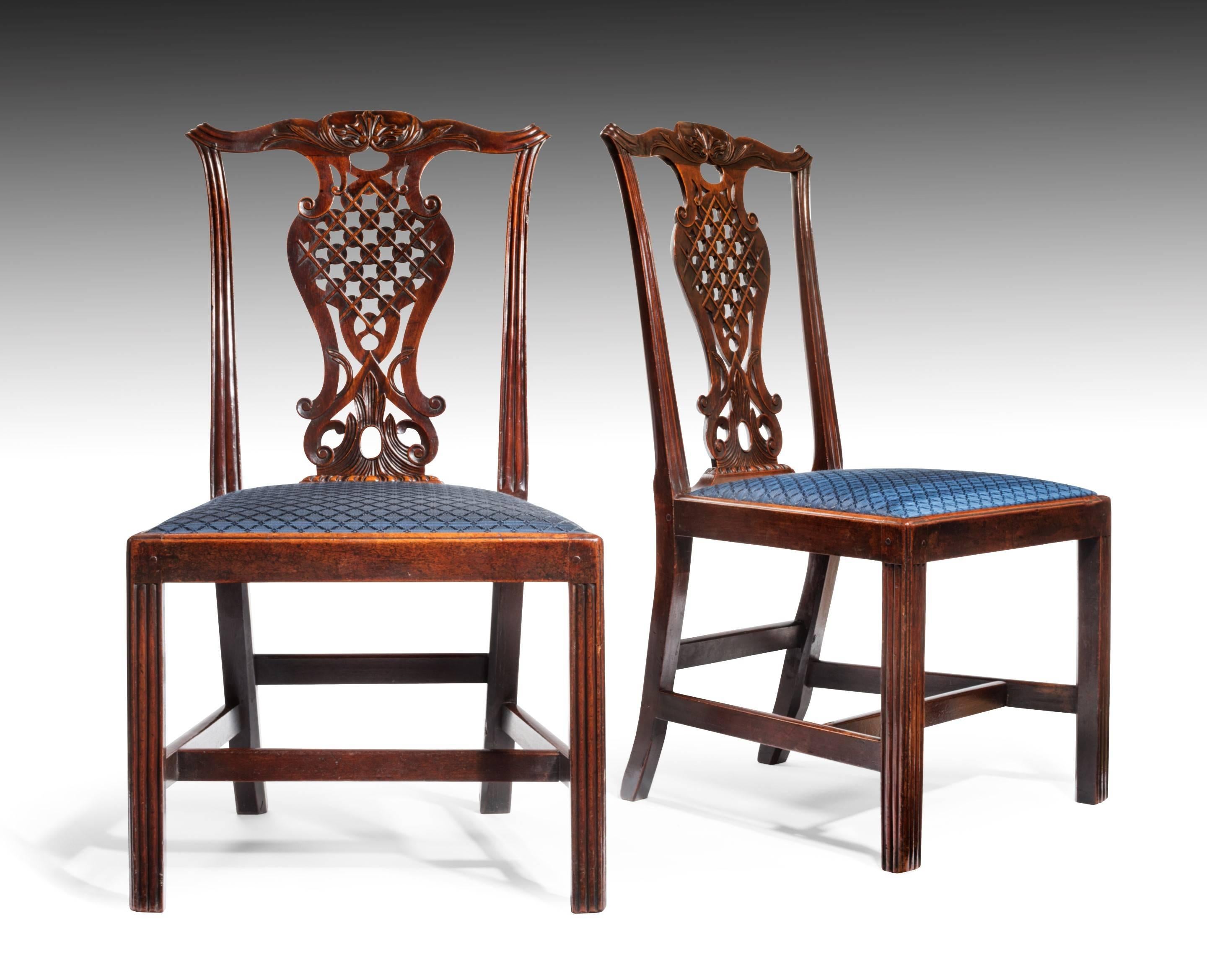 An exceptional pair of rare George III period mahogany side chairs, with a Chinese lattice back splat, after the designs of Robert Mainwaring. The carving is well drawn and finely executed, with the back view of the back-splat every bit as