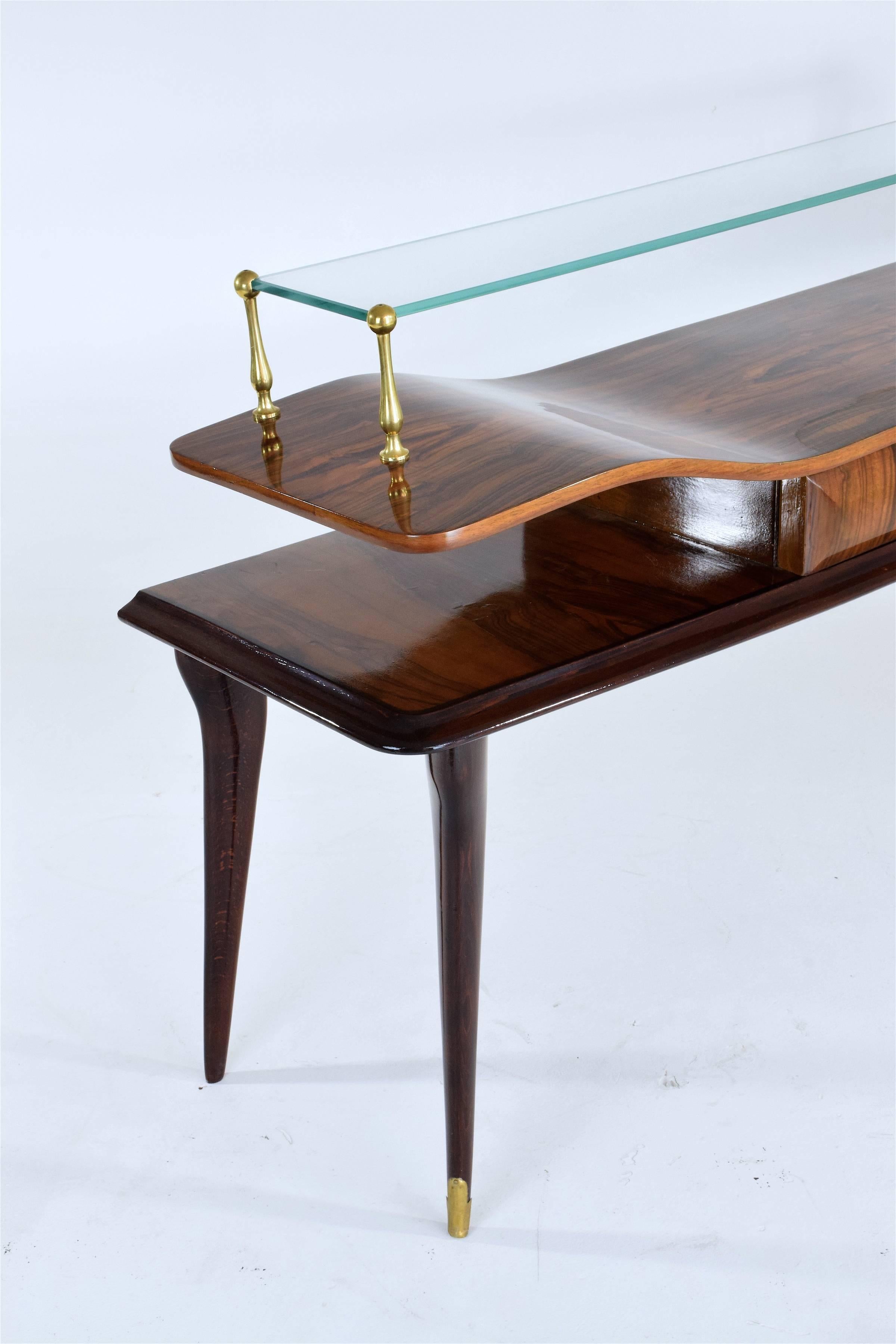 Italian 20th century design vintage low curved console table or sideboard in veneered wood composed of its original glass shelf, sculpted brass details and a central drawer. The splayed legs are adorned with brass endings.

In beautiful restored