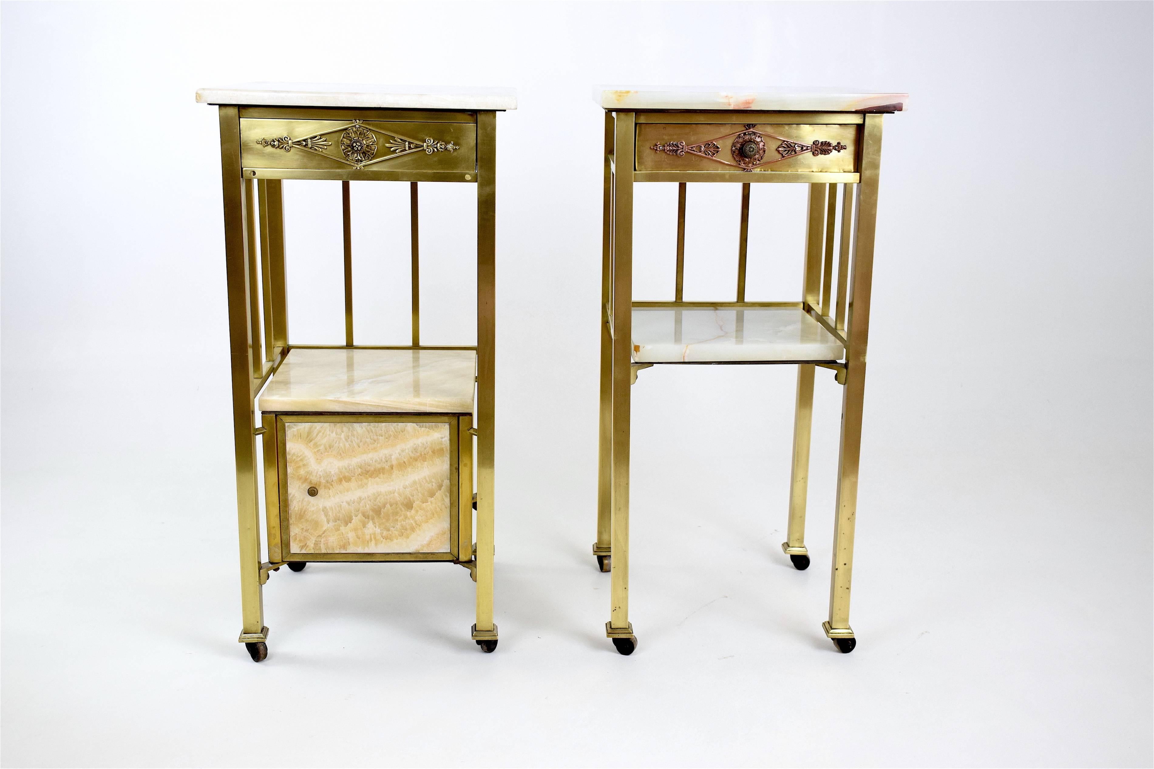 20th Century pair of high French two-tier nightstands or side tables with rollers, marble tops, brass and wooden shelves adorned with floral details in brass or copper. 

One of the pieces is composed of a  lower cabinet and has been previously