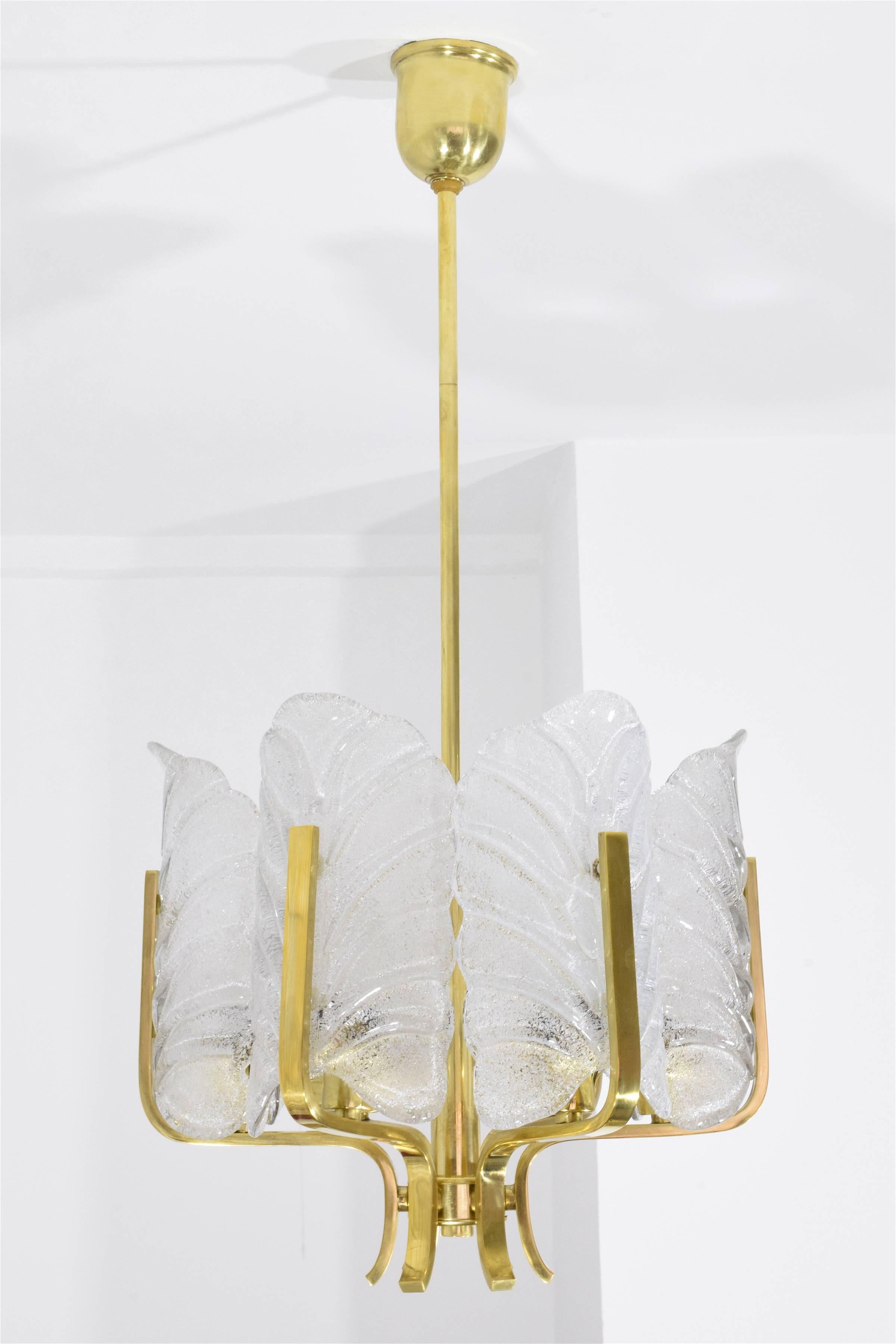 A chandelier attributed to Swedish designer Carl Fagerlund for Orrefors in a Hollywood Regency style circa 1960's. It is composed of six textured Murano glass leaves and a polished brass structure. Great graphic effect when visualized from the