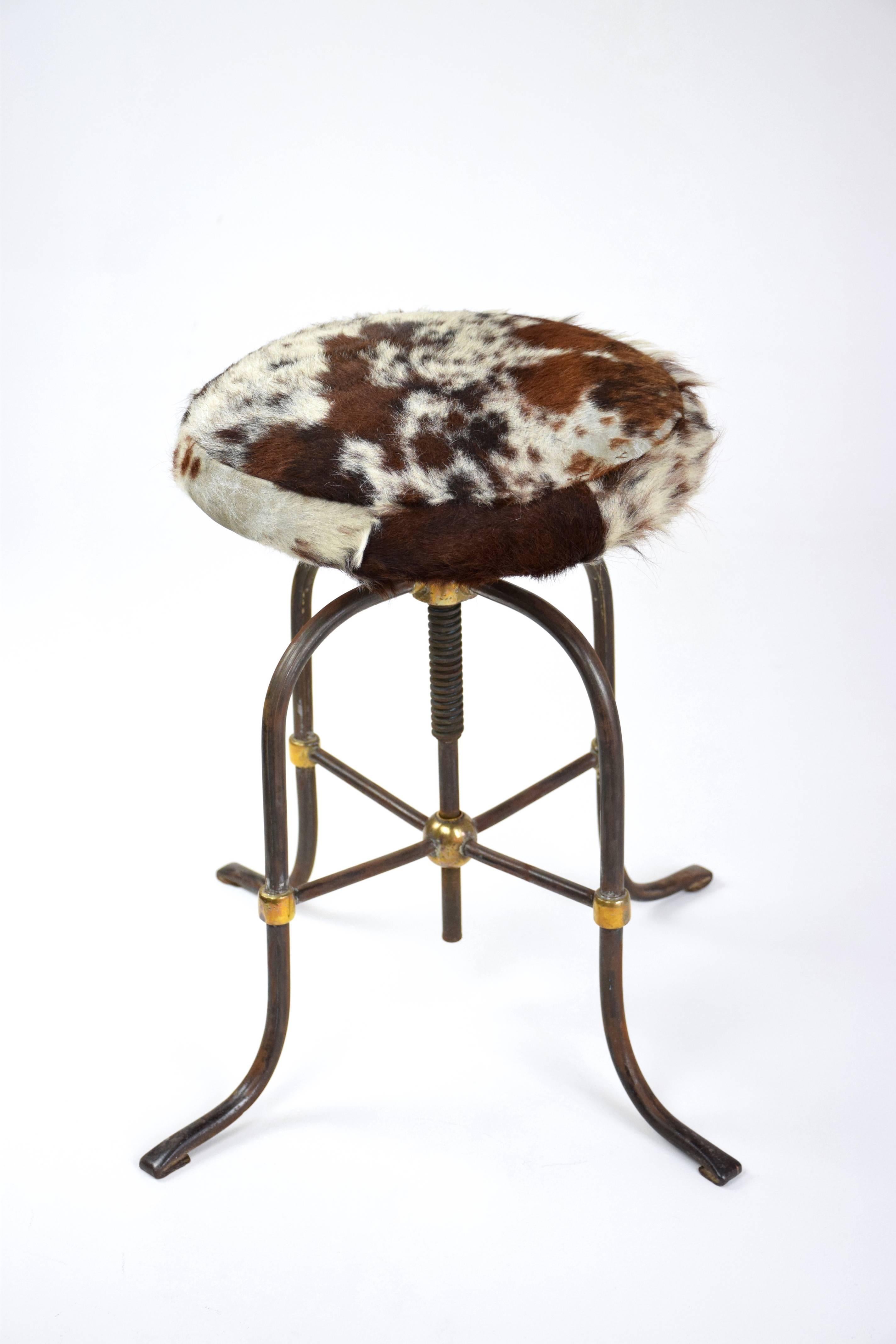 Fantastic original French Art Deco, 20th Century stool from the 1930's with an adjustable cowhide seat, Industrial inspired steel structure with brass sphere details and cabriole style legs.
In its original vintage condition.
  