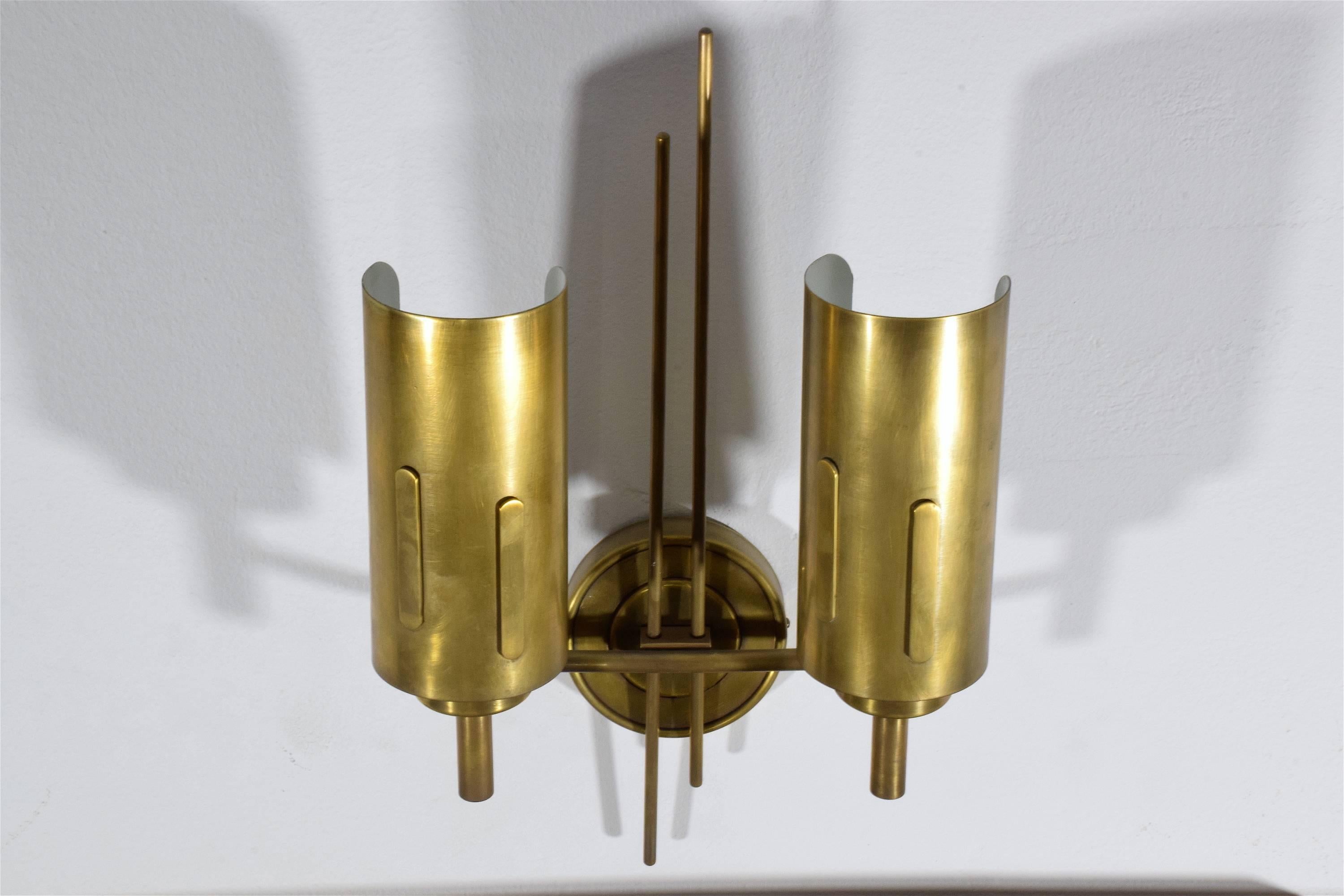 Italian set of two 20th century vintage mid-century wall lights composed of solid polished brass and designed with graphic art deco style details.
Italy. Circa 1950's. 

Do not hesitate to let us know if you wish to request a particular finish: