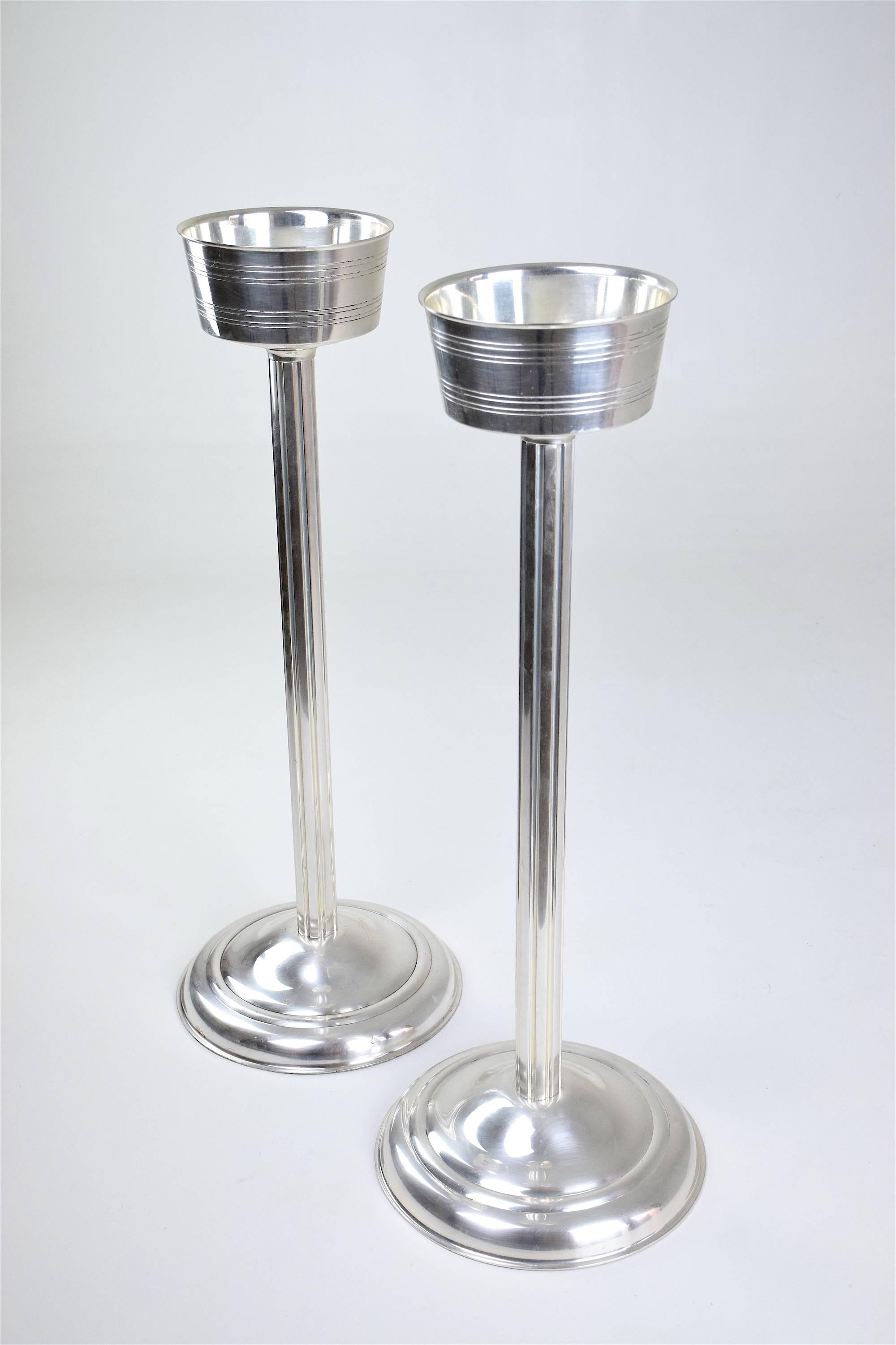 Pair of heavy silver plated solid brass stands for champagne buckets, wine coolers or even ice coolers in Art Deco style. 
Surfaces have been professionally refinished. 
These could be found in luxurious hotels and palaces. 
France. circa 1960s.