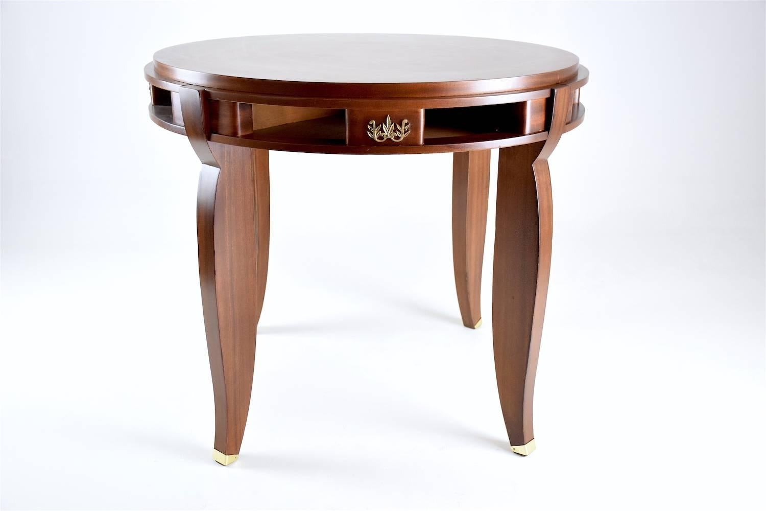 20th century vintage restored game table designed by one of the main precursor of Art Deco, Jules Leleu, circa 1930s. Elegant, large round gueridon or game table in rosewood and walnut veneer with inlaid parquetry, four brass leaf floral details,