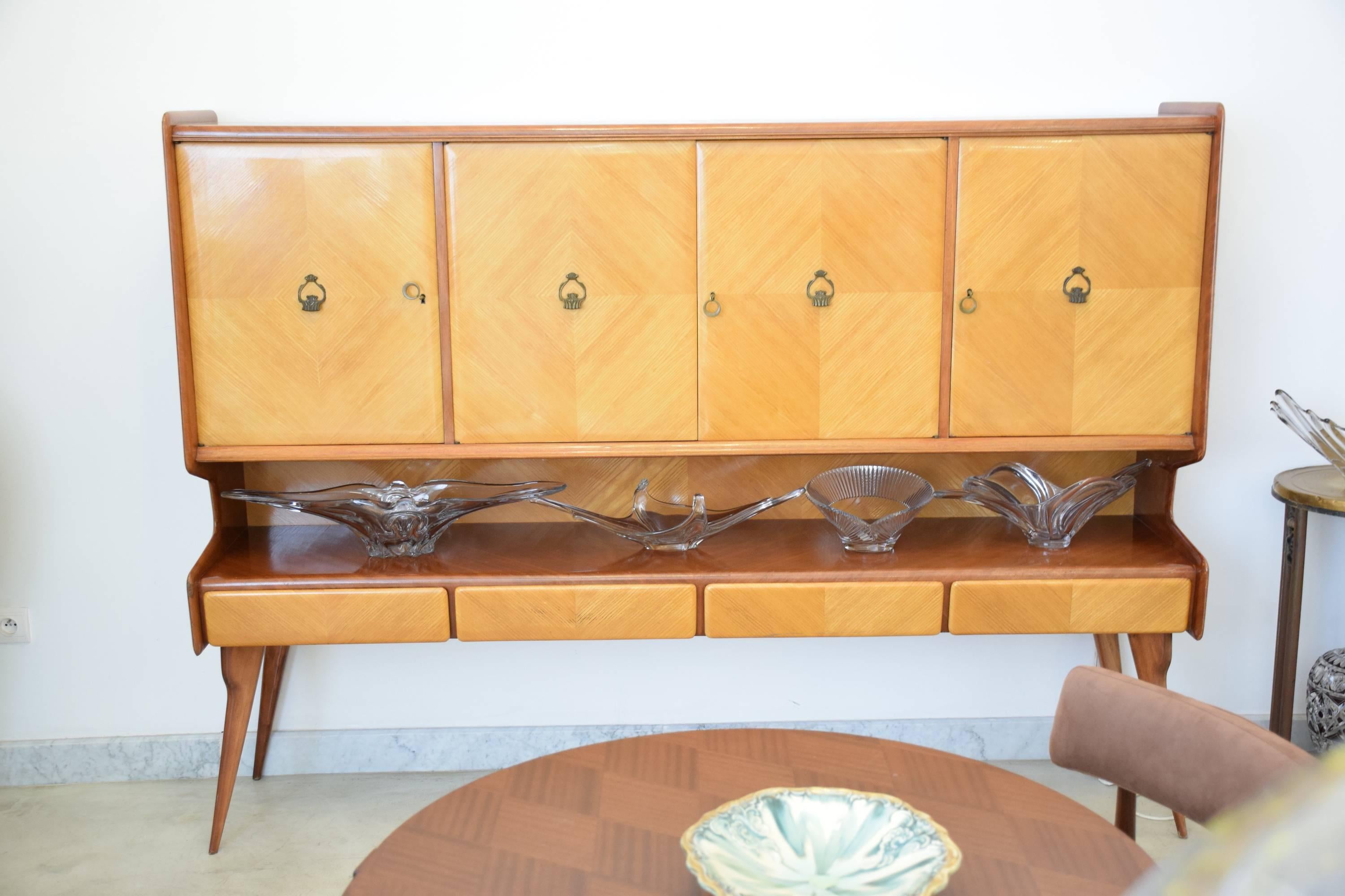 20th century vintage Italian design buffet or credenza typical of the midcentury period which can be used as a case piece and sideboard storage cabinet space.
Designed and crafted in the style of Ico Parisi, built out of mahogany and maple wood