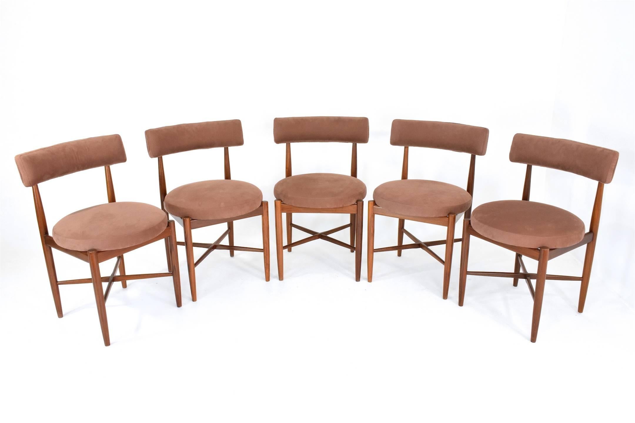 A set of four British manufacturer G-Plan dining chairs designed by Danish designers Victor Wilkins or Koford Larsen at the end of the 1960s. Each chair is composed of re varnished tapered legs and cross shapes stretchers. The comfortable circular