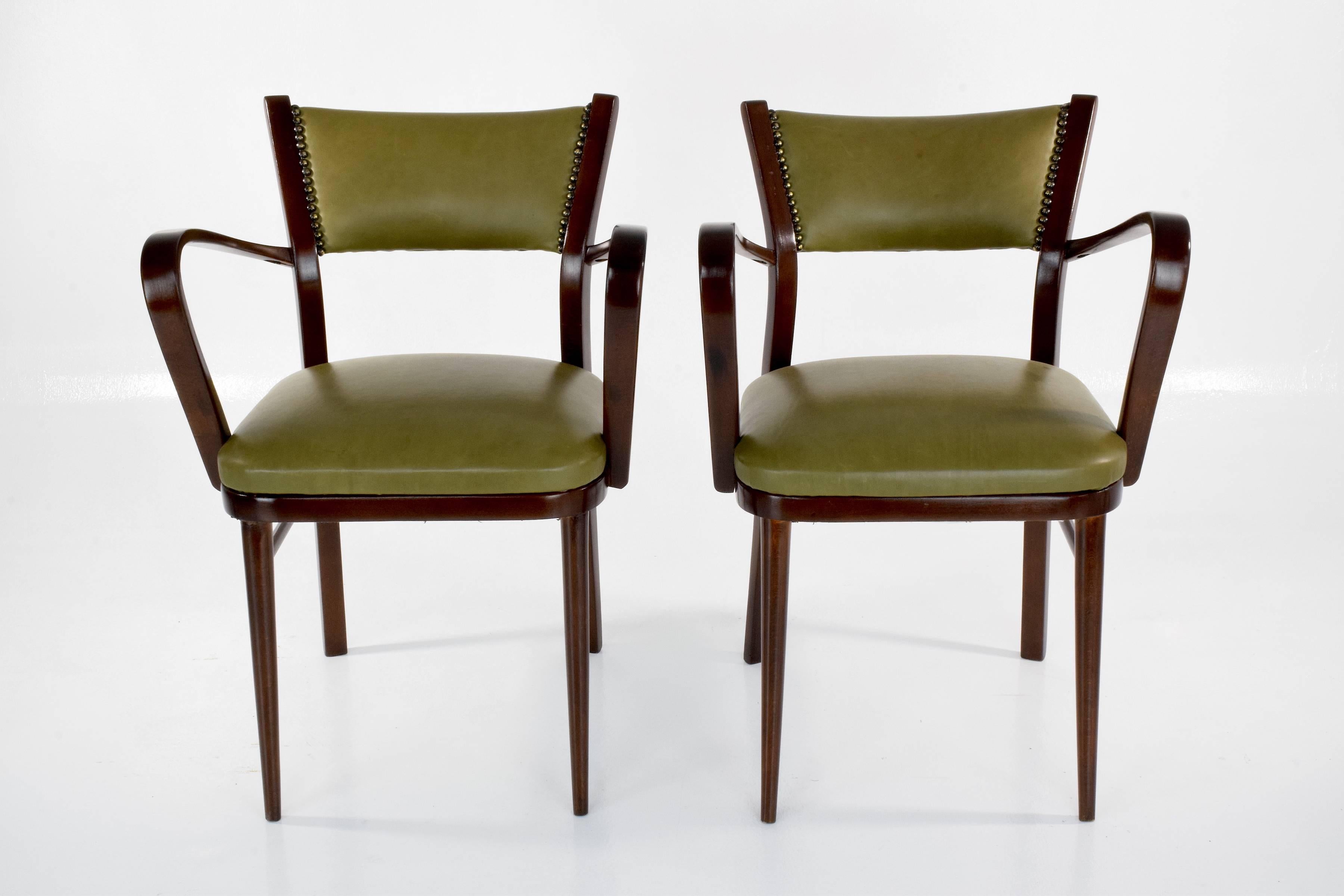 Set of two Italian 20th-century vintage side chairs composed of stained bent beechwood with elaborately curved arms with side stretchers and beautiful splayed tapered legs. 
Restored, varnished and re-upholstered with Italian green leather and