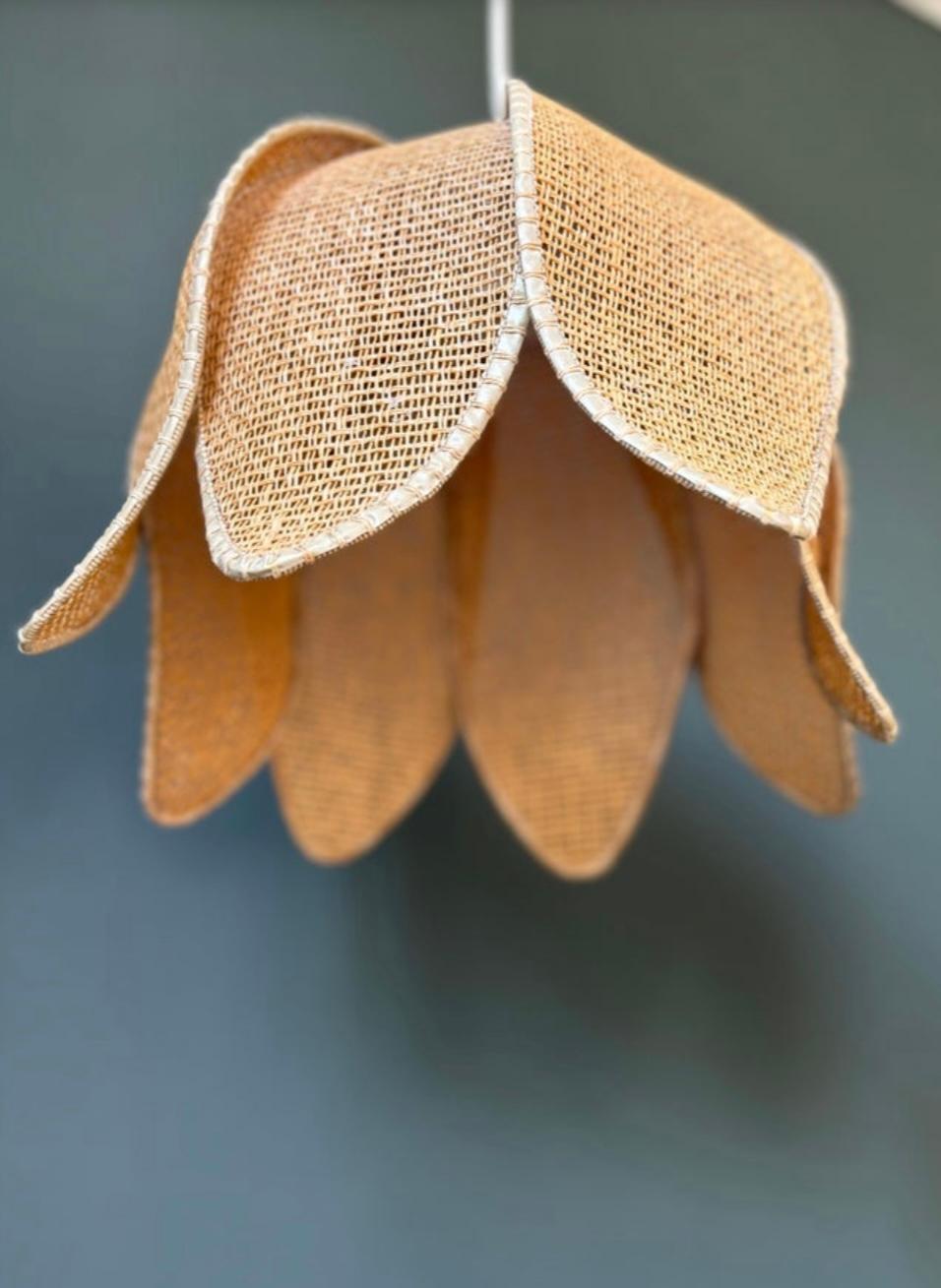 Uno dei due ciondoli fatti a mano a forma di fiore in rattan organico moderno intrecciato naturale di colore marrone chiaro. Otto lati stratificati con bordi color beige e filo marrone chiaro abbinato per formare una forma organica morbida e