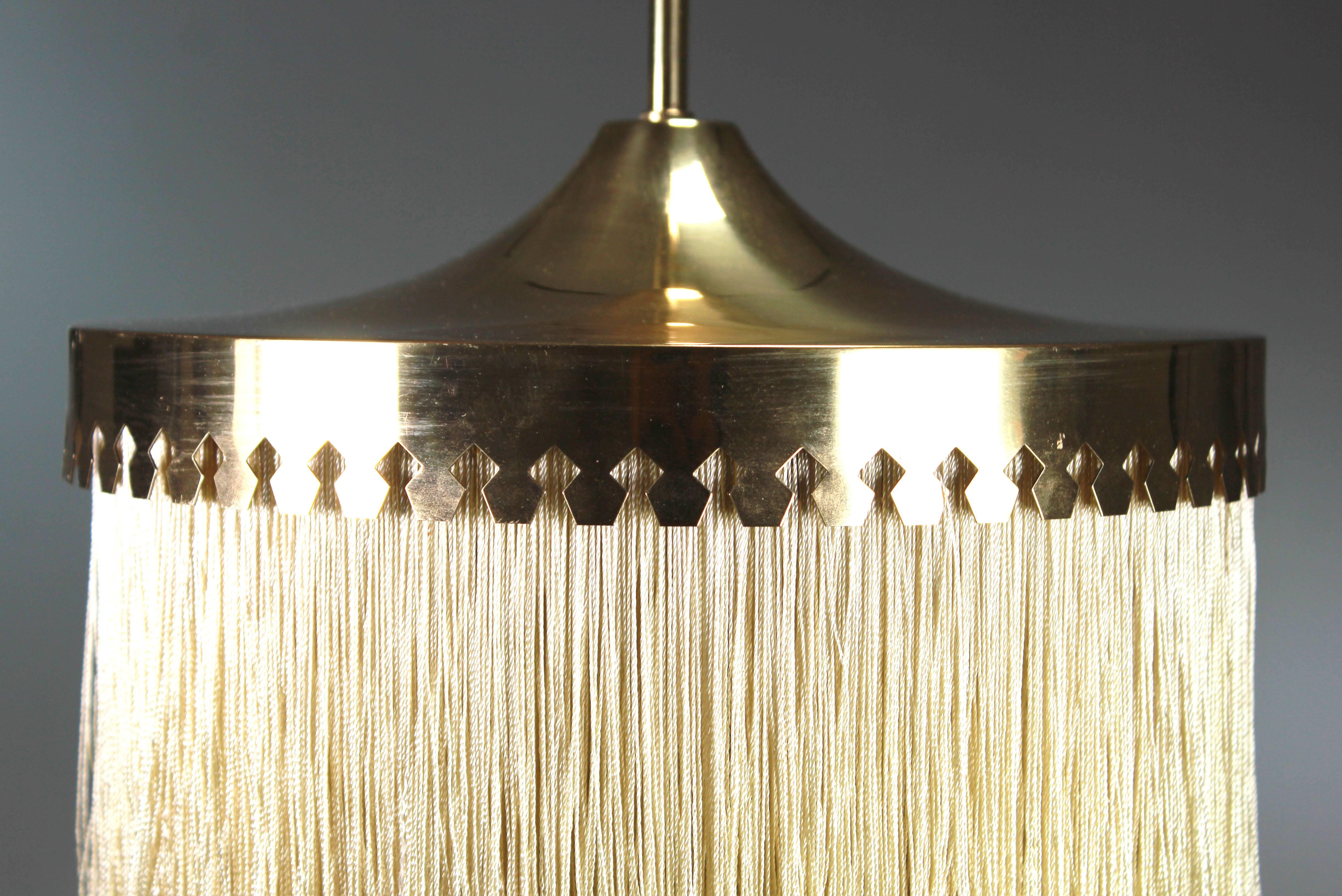 Swedish elegance! Scandinavian Mid Century Modern extraordinary pendant by the great Swedish designer Hans Agne Jakobsson. Five separate layers of sand colored silk fringes with polished brass frame and original polished brass stem. One E27 bulb