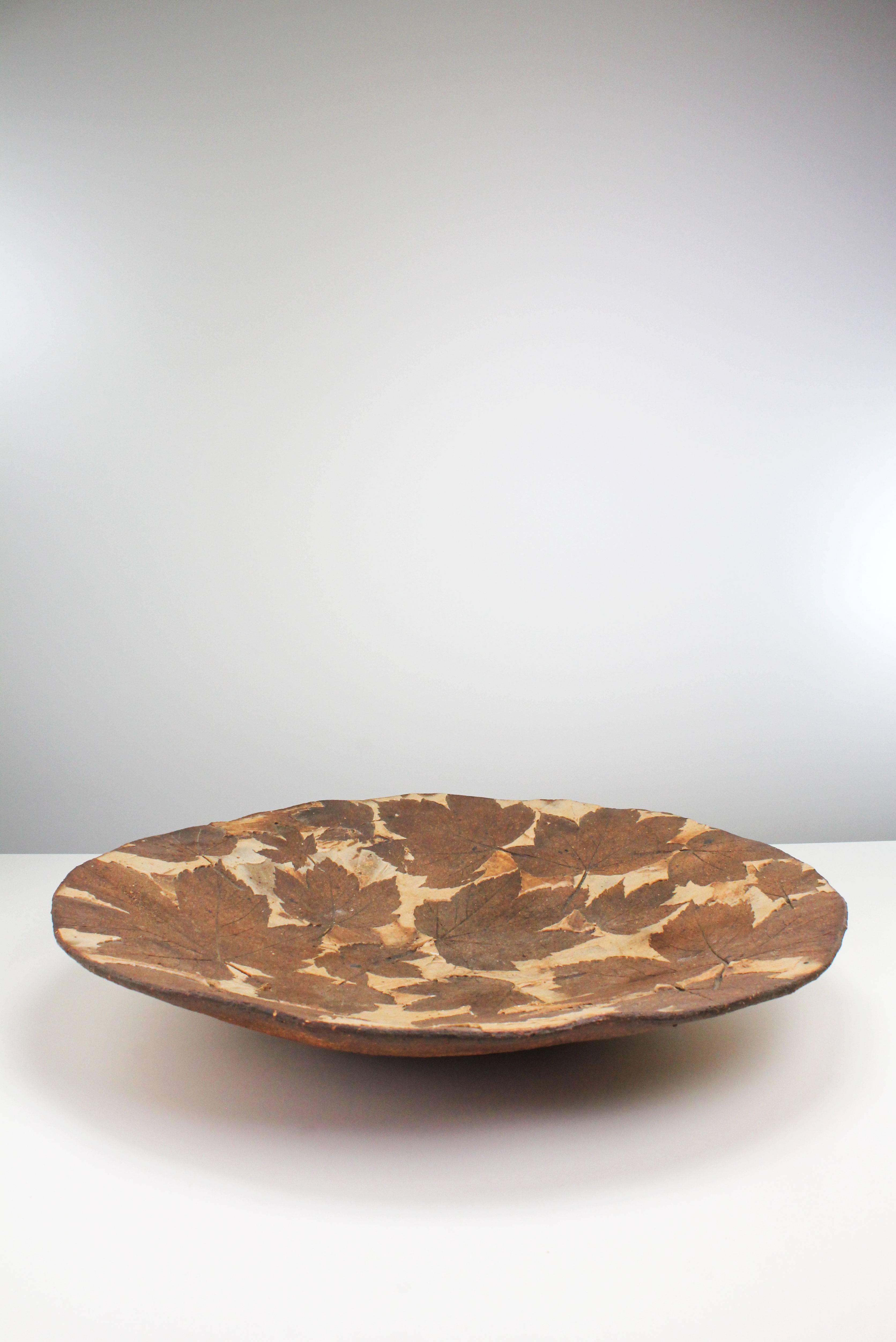 One of a kind, handmade and hand decorated centerpiece or wall decoration by experimental Danish artist Bodil Marie Nielsen. Imprints of actual leaves and stems are made into the ceramic material in natural brown colors. Artist's name and 
