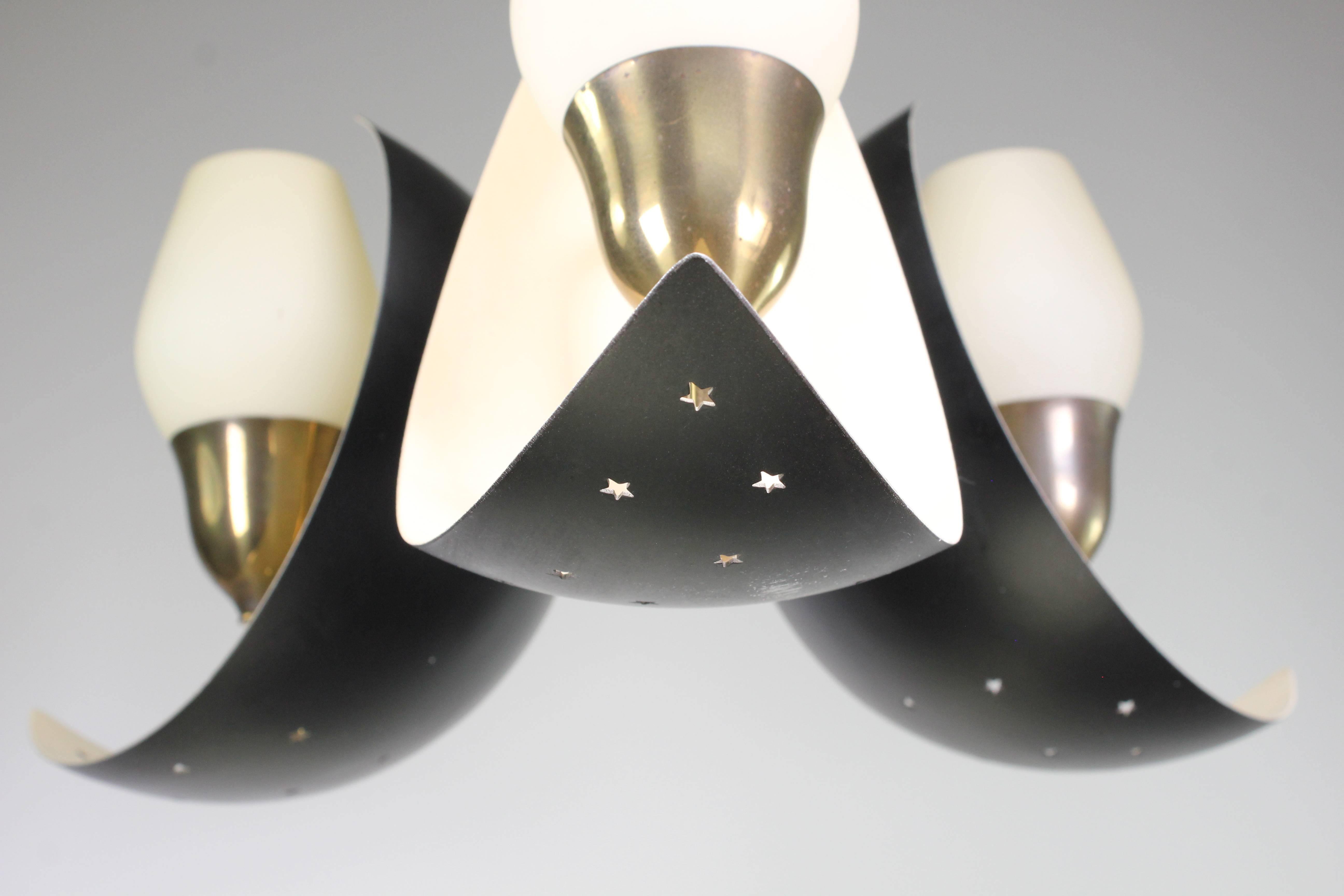 Black and cream white lacquered metal pendant with brass arms and white tulip shaped opaline glass by Danish designer Bent Karlby for Fog and Mørup. On a brass mount are three crescents that are black on the outside and white on the inside. Each