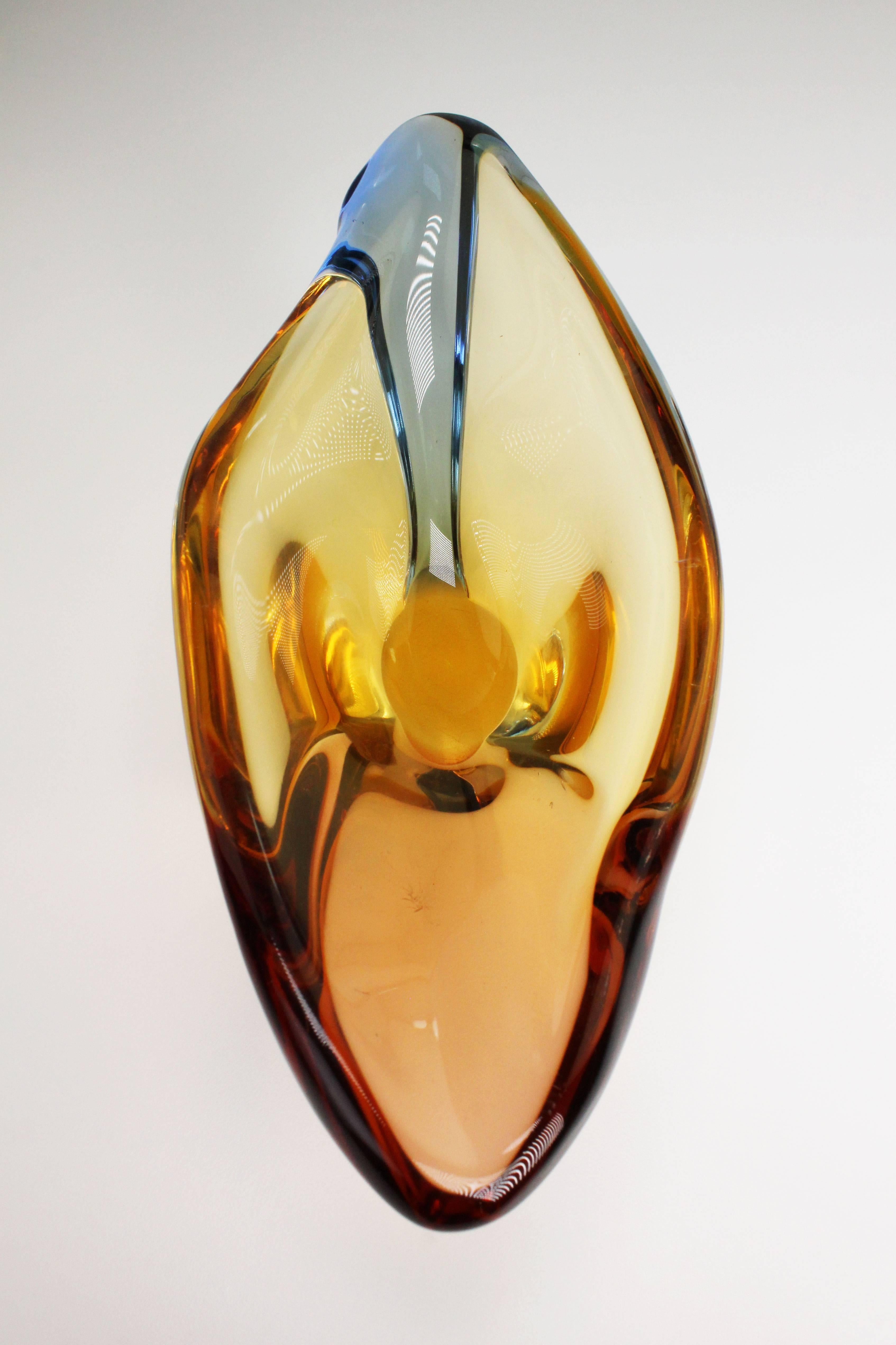Spectacularly beautiful Mid Century Modern handblown smooth, asymmetrical art glass bowl in solid glass by Czech designer Hana Machovska for Mstisov. Golden, red and blue colors. From the Romana series designed and manufactured in 1960. In