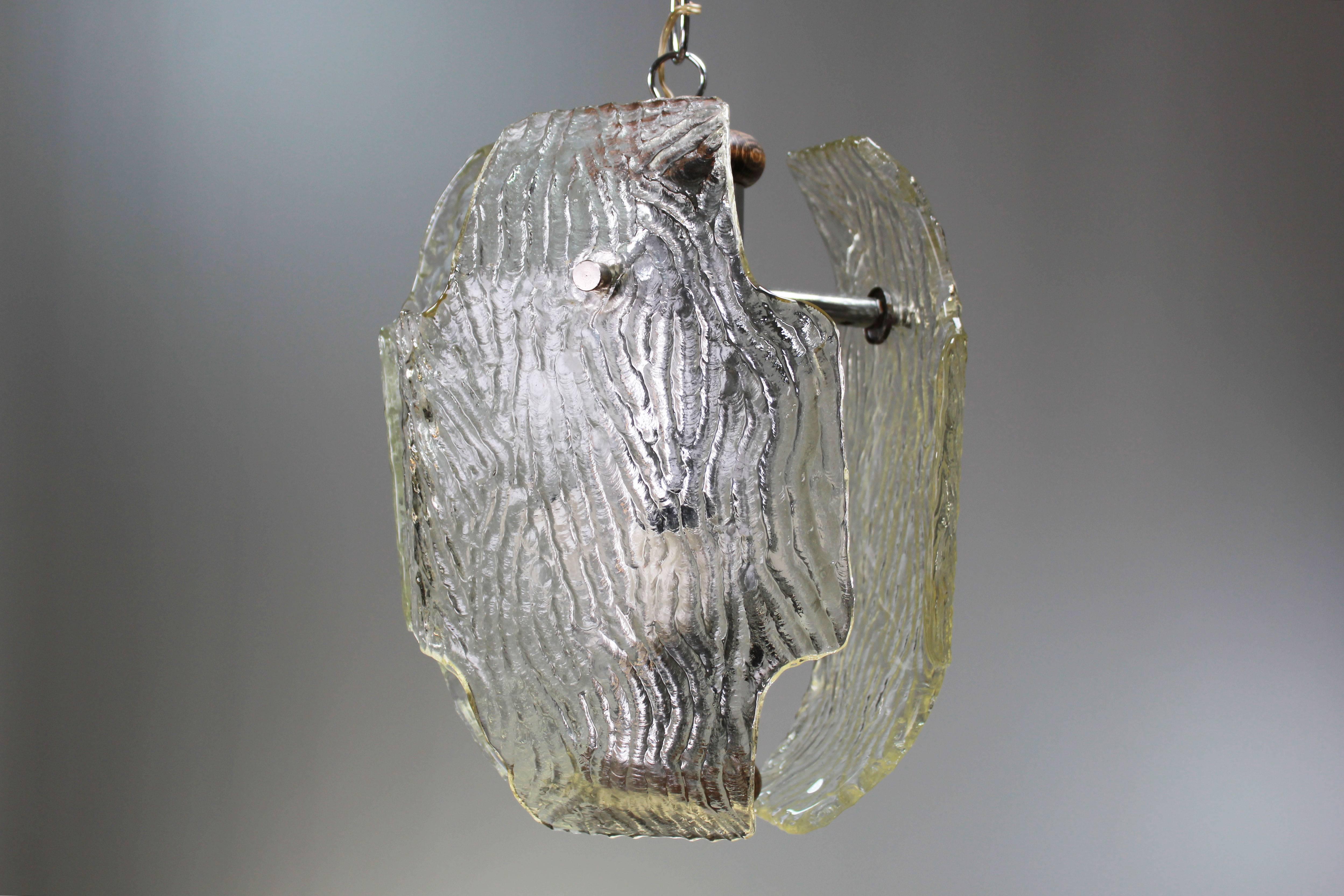 Suspension italienne Murano du milieu du siècle avec trois grandes plaques de verre transparent texturé et quincaillerie en métal. Chaîne en métal brillant d'origine et dessus et dessous en bois. Fabriqué sur l'île vénitienne de Murano dans les