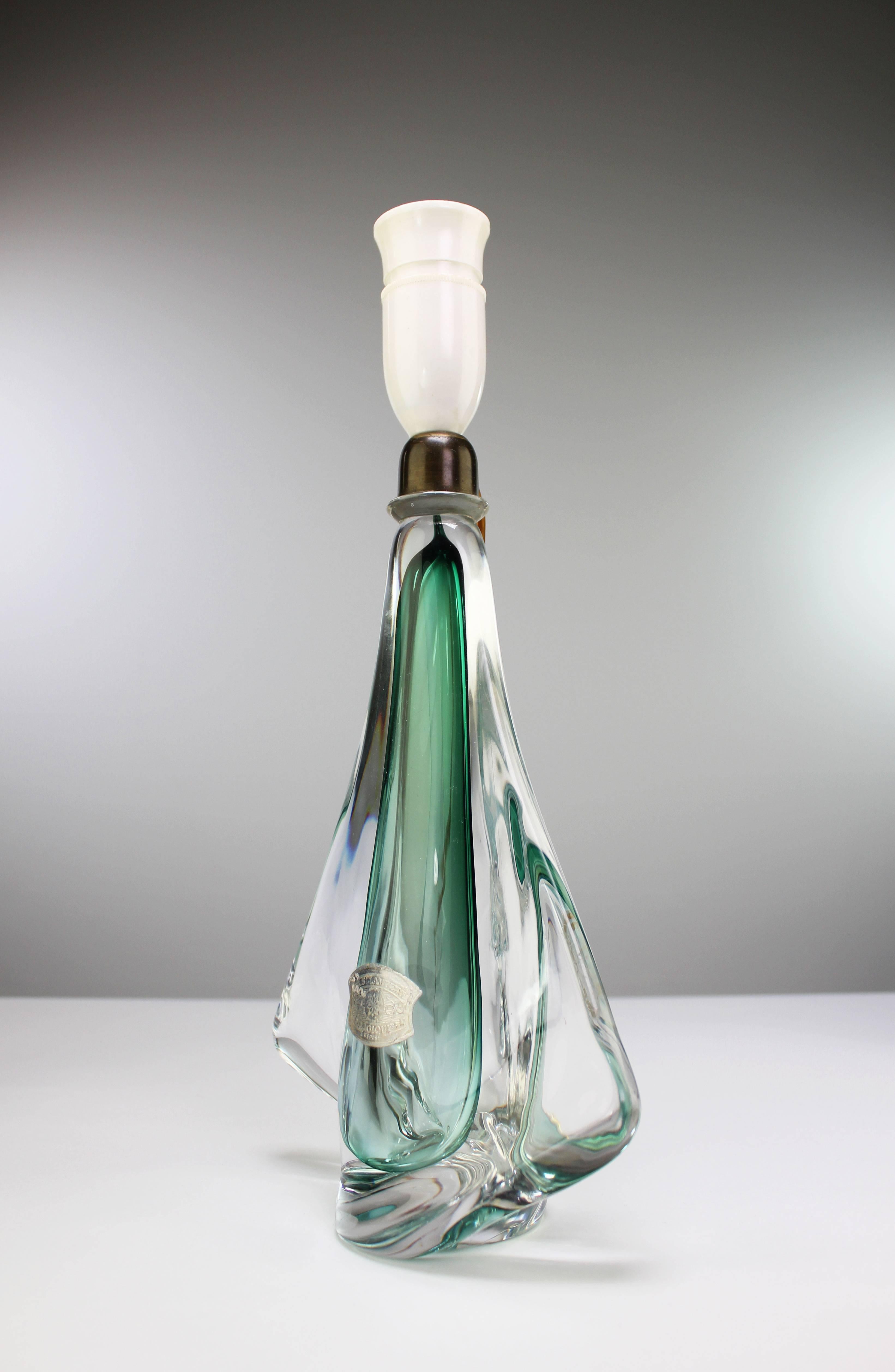 Lampe de table en cristal soufflé belge du milieu du siècle, en cristal vert émeraude enchâssé dans du cristal clair, par Val Saint Lambert. De forme organique avec une aile transparente de chaque côté et un sommet arrondi en laiton. Labellisé au
