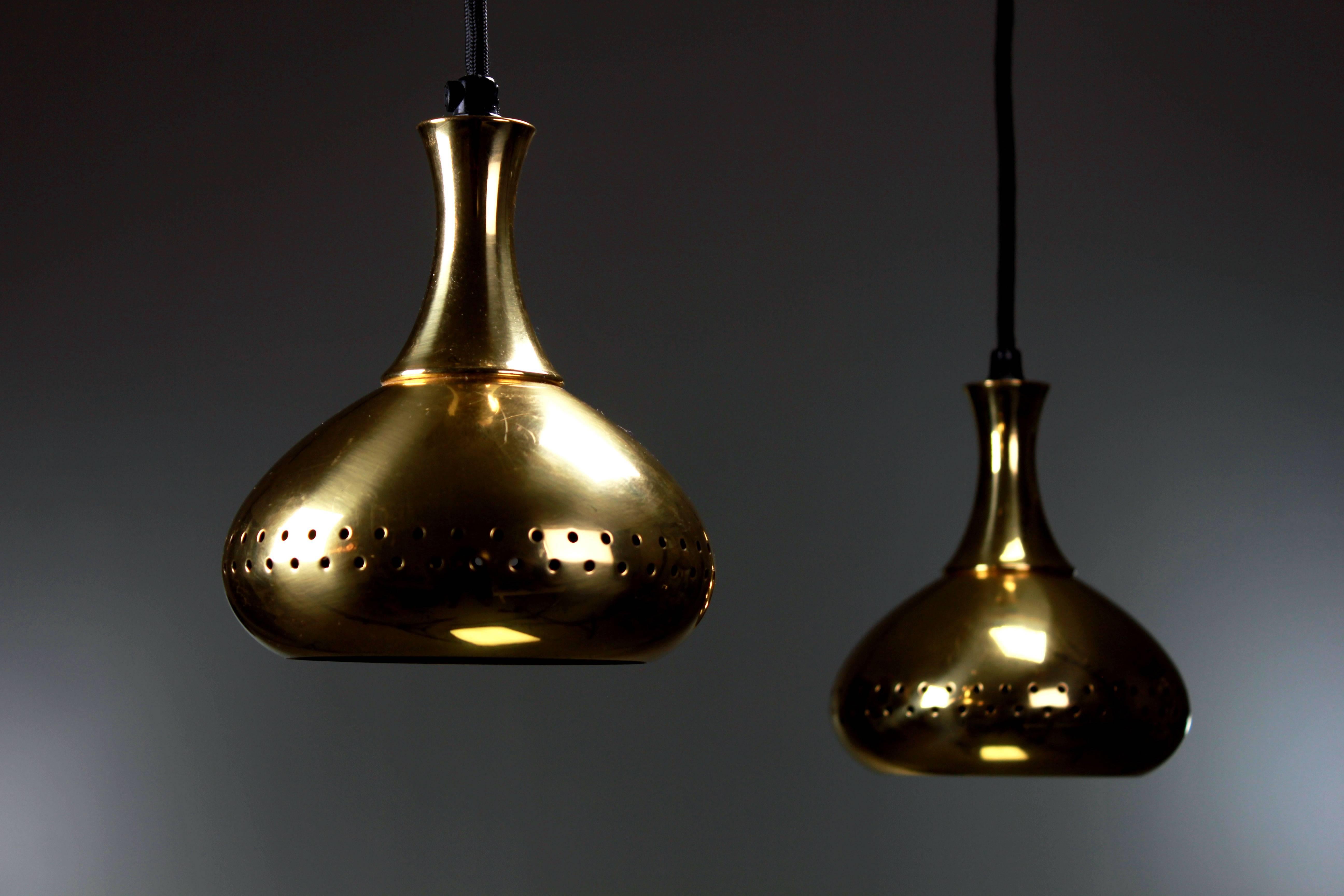 Beautiful pair of Scandinavian Mid Century Modern brass pendants with perforated details to let the light shine through. By Swedish designer Hans-Agne Jakobsson and manufactured in Sweden in the mid 1960s. Both rewired and in beautiful condition.