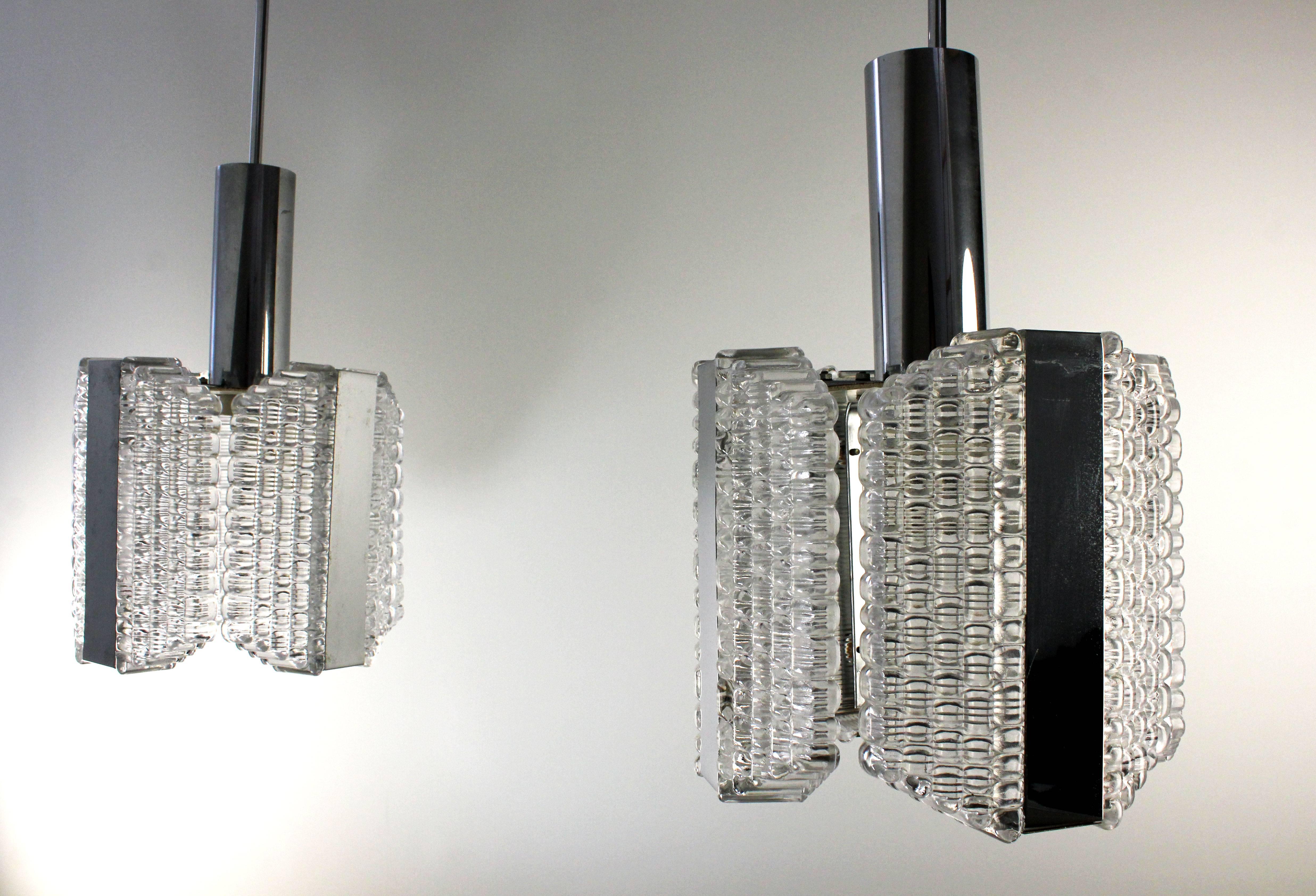 Elegante par de colgantes modernistas de la era espacial con cuatro placas de cristal de textura suave sobre montura cromada. Vástago largo y delgado cromado y tejadillo. Fabricado por Kaiser Leuchten en la década de 1960. Etiquetado en el