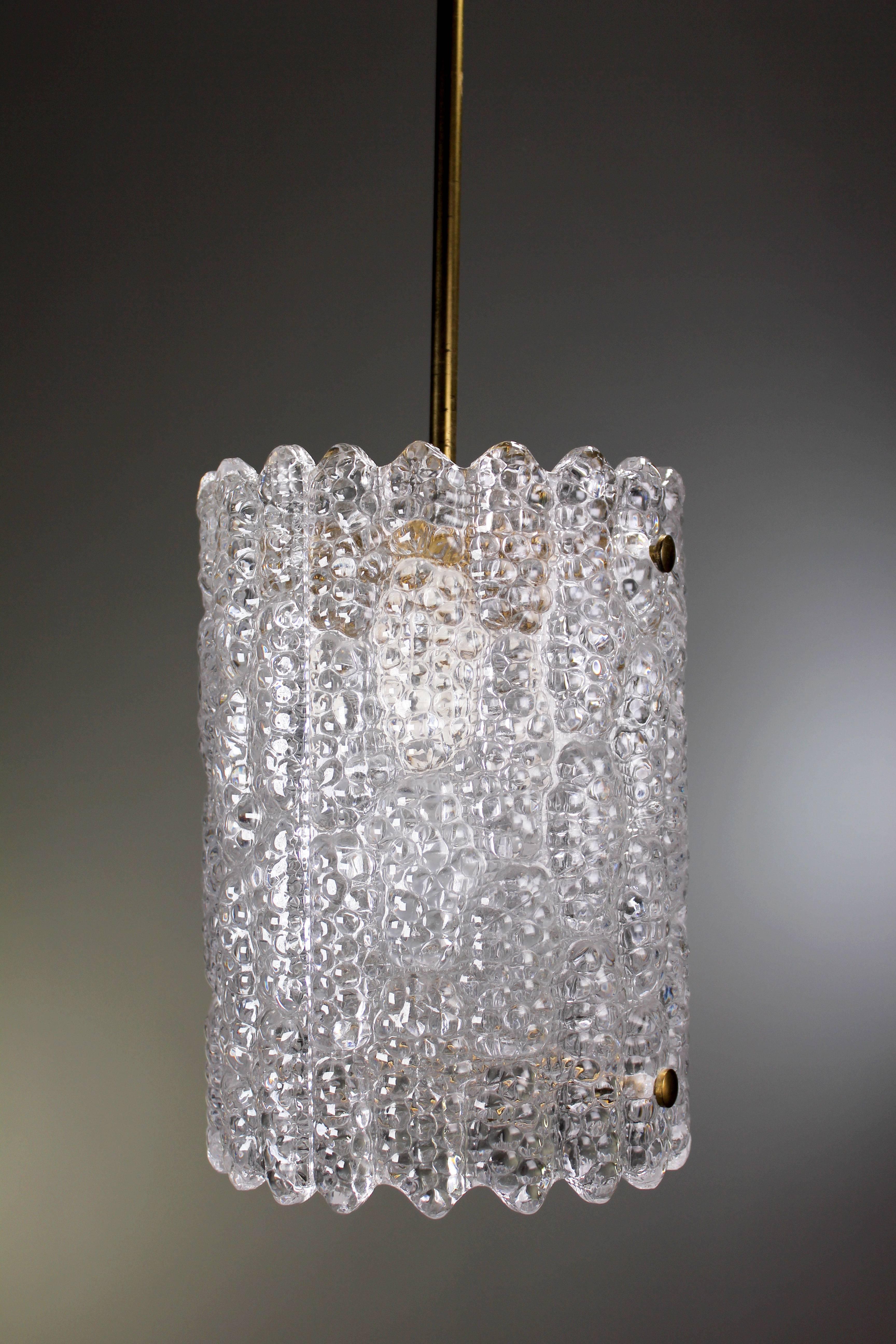 Stunning midcentury Scandinavian modern cylinder pendant by Swedish designer Carl Fagerlund for Orrefors Glasbruk. Clear textured crystal with scalloped edges. Original brass hardware, slender stem and canopy. Manufactured in the 1950s in the small