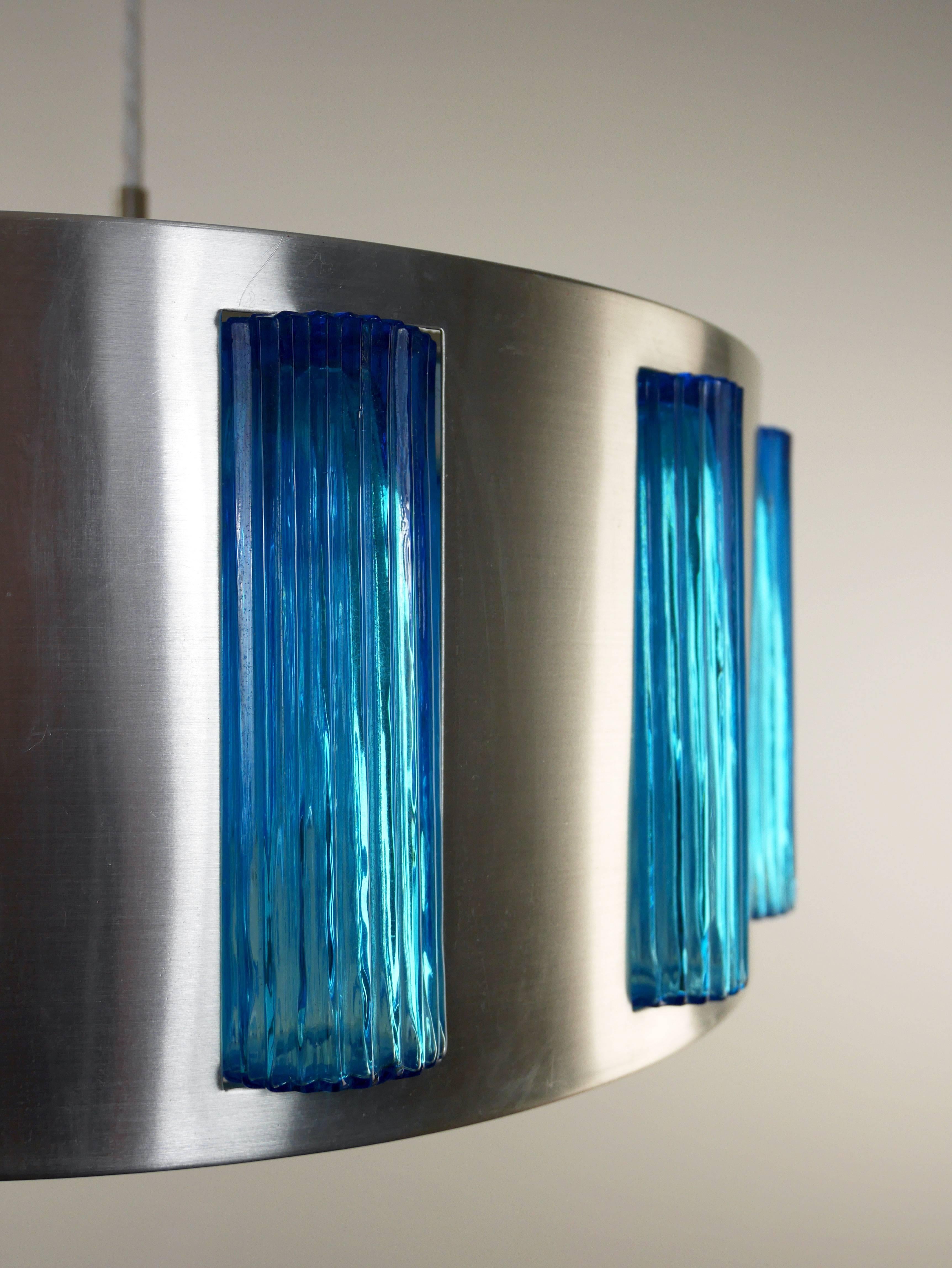 Midcentury Swedish modern drum shaped pendant in aluminium with textured blue glass cylinders by Orrefors (attributed). Top and bottom plates in structured, transparent acrylic.