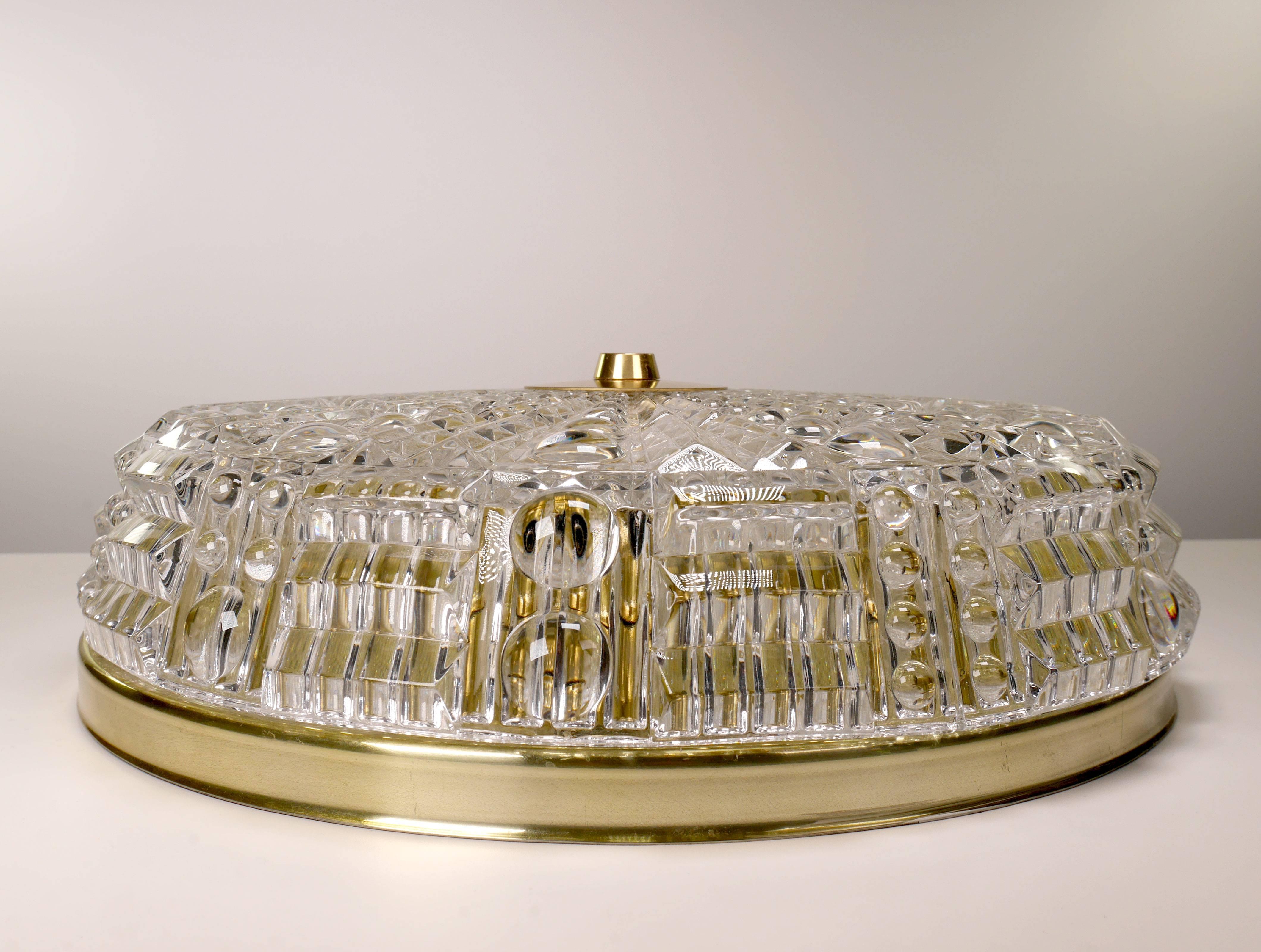 An absolute classic within Swedish Mid-century Modern glasswork! Swedish Mid-Century Modern one-piece textured crystal flush mount. Modernist design by Carl Fagerlund in the late 1950s-early 1960s for Swedish Orrefors Glasbruk. Brass mount and