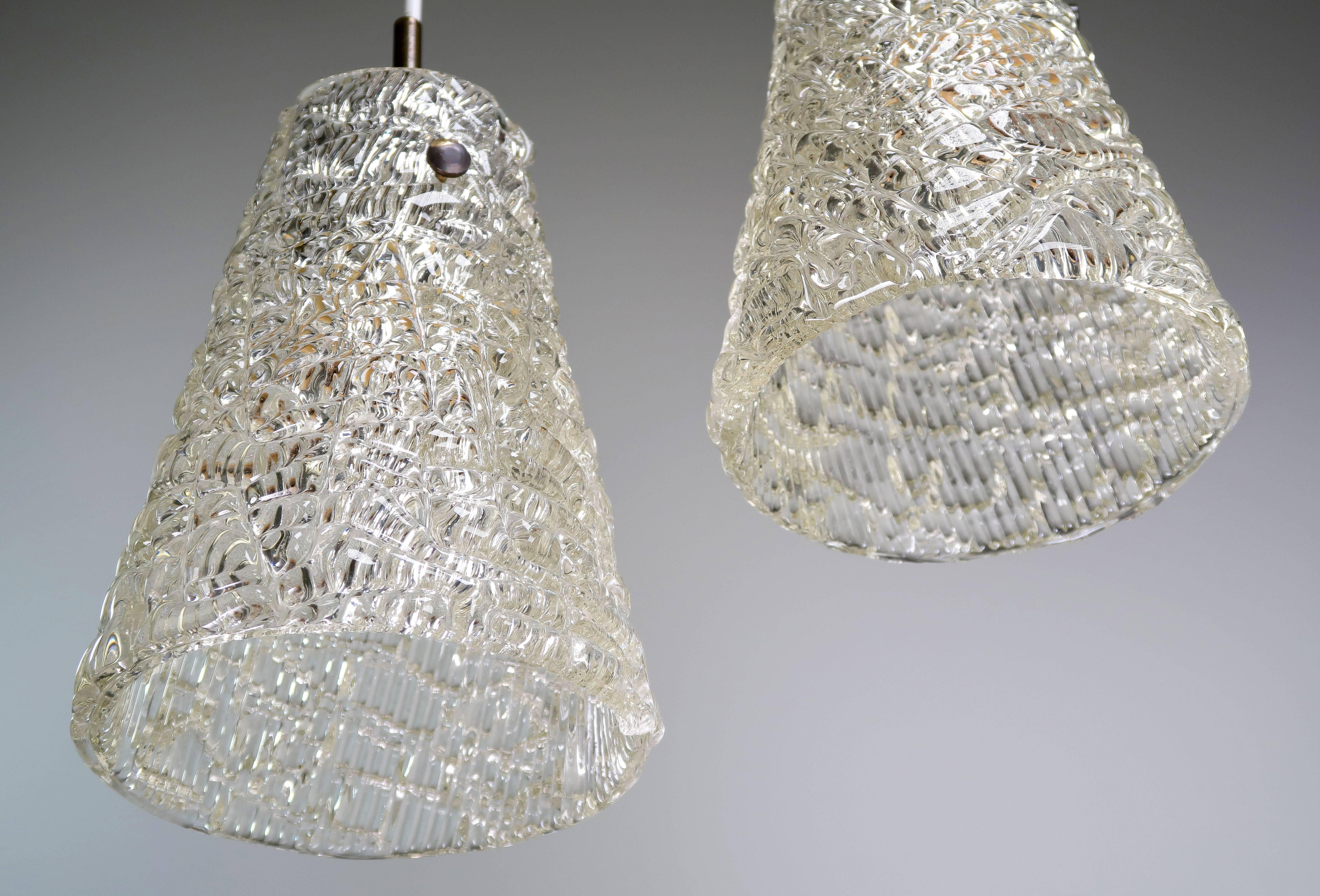 Beautiful and rarely seen pair of Scandinavian Mid Century Modern cone shaped glass pendants by Swedish Orrefors. Handblown clear textured glass with brass hardware. Designed by Carl Fagerlund in the 1960s. E27 bulb. Rewired and in excellent vintage
