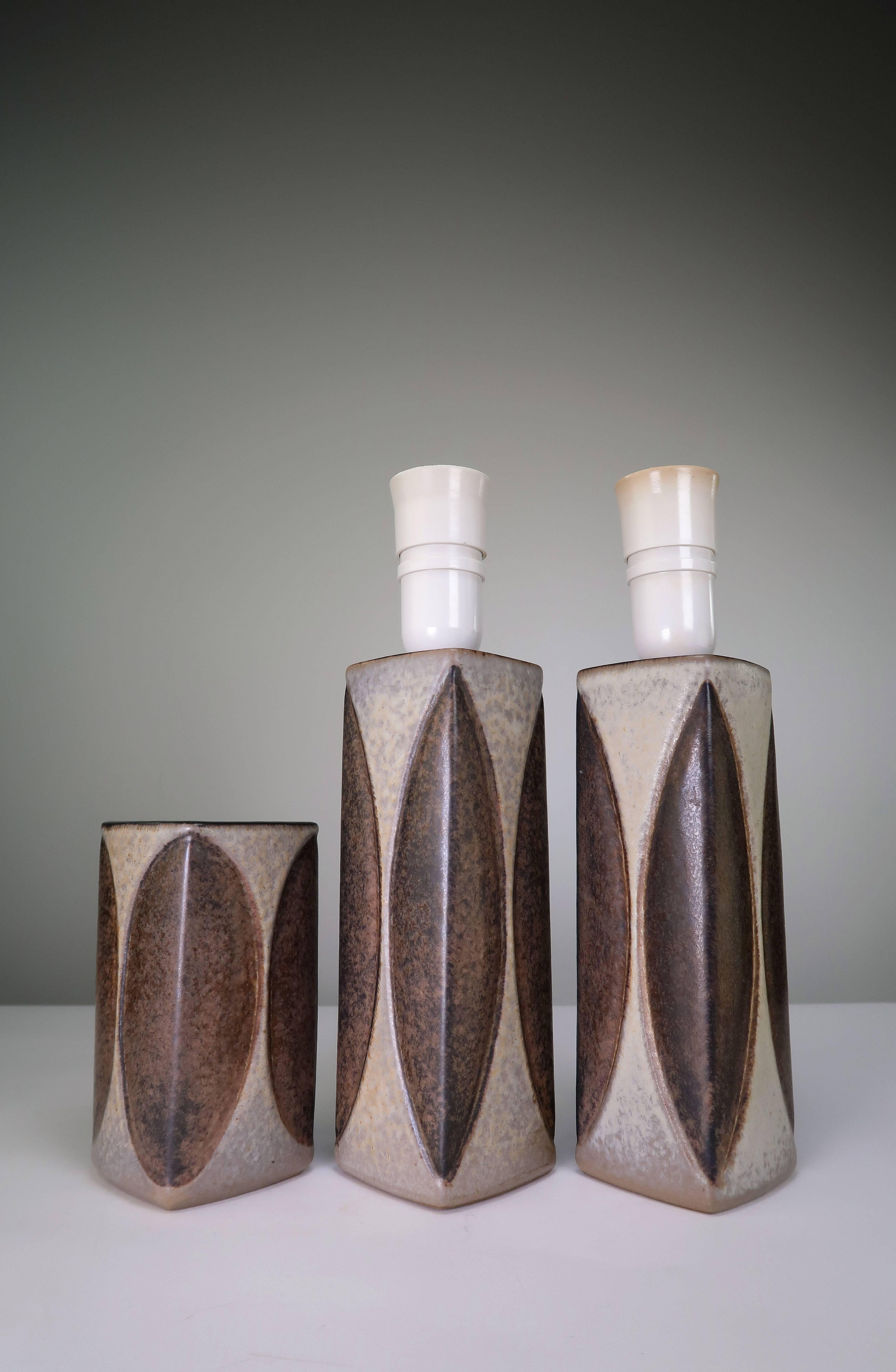 Danish Mid-Century Modern ceramic pieces by ceramic artist Marianne Starck for Michael Andersen & Son. Two table lamps and one vase from the same series. Rectangular and geometric shapes with glaze in grayish cream and chestnut brown. Switch on