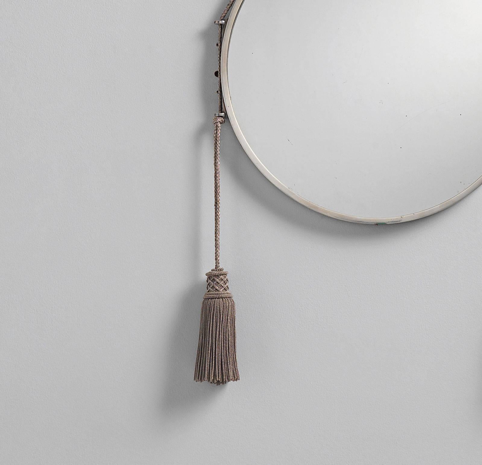 An original Art Deco mirror with tassels by Emile-Jacques Ruhlmann, circa 1920. Made entirely from silver-plated bronze with hand woven passementarie detail. Appearance and wear consistent with age - minor scratching on mirror face.