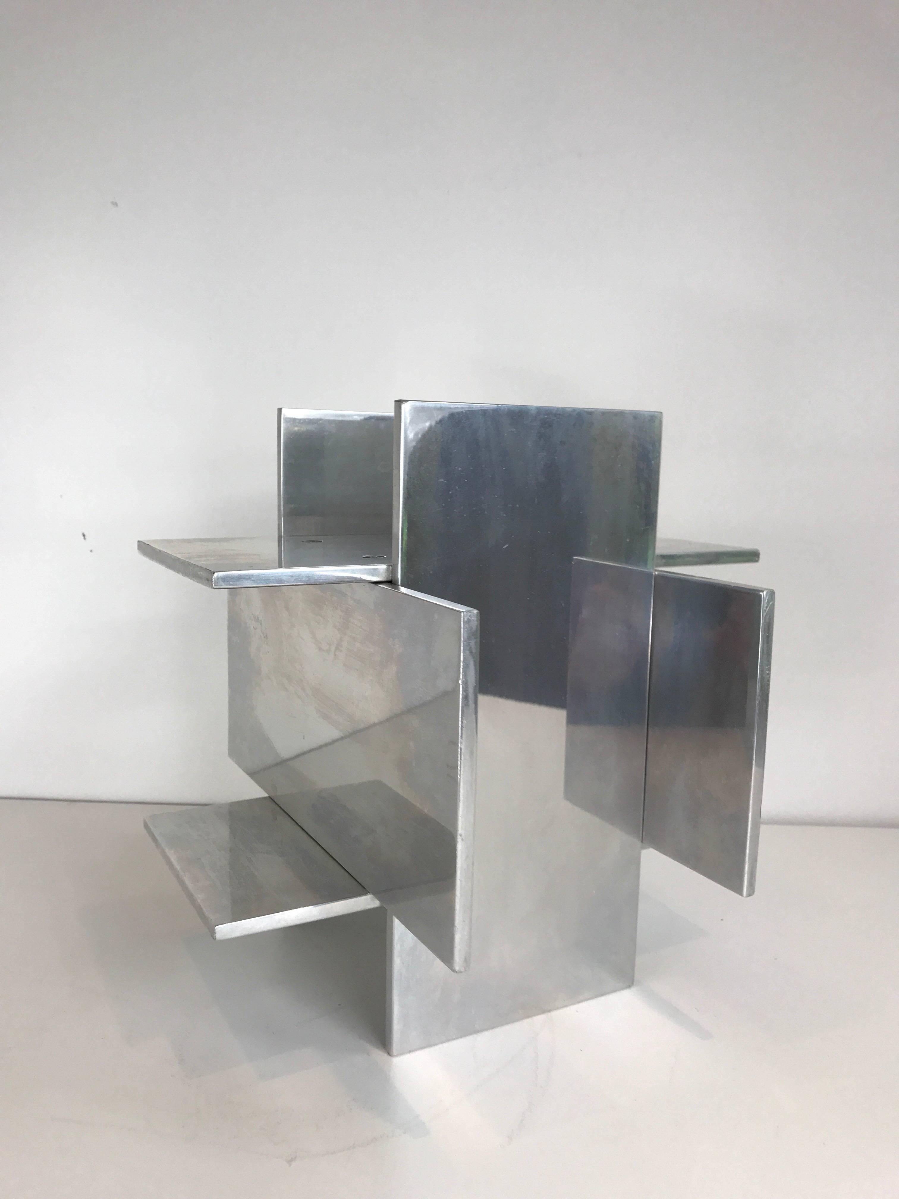 A midcentury chromed steel tabletop sculpture with geometric form and riveted plates.