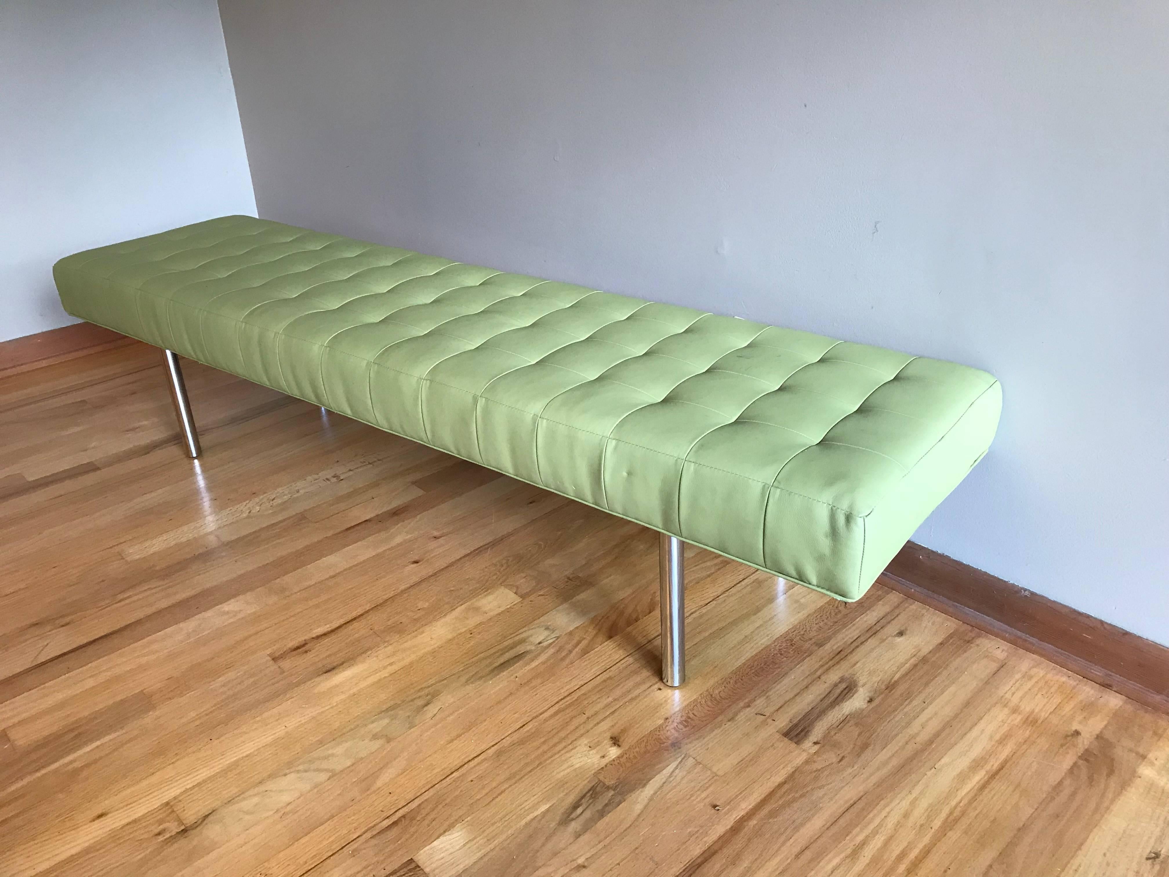 A long pale green tufted leather bench with tubular chrome legs.