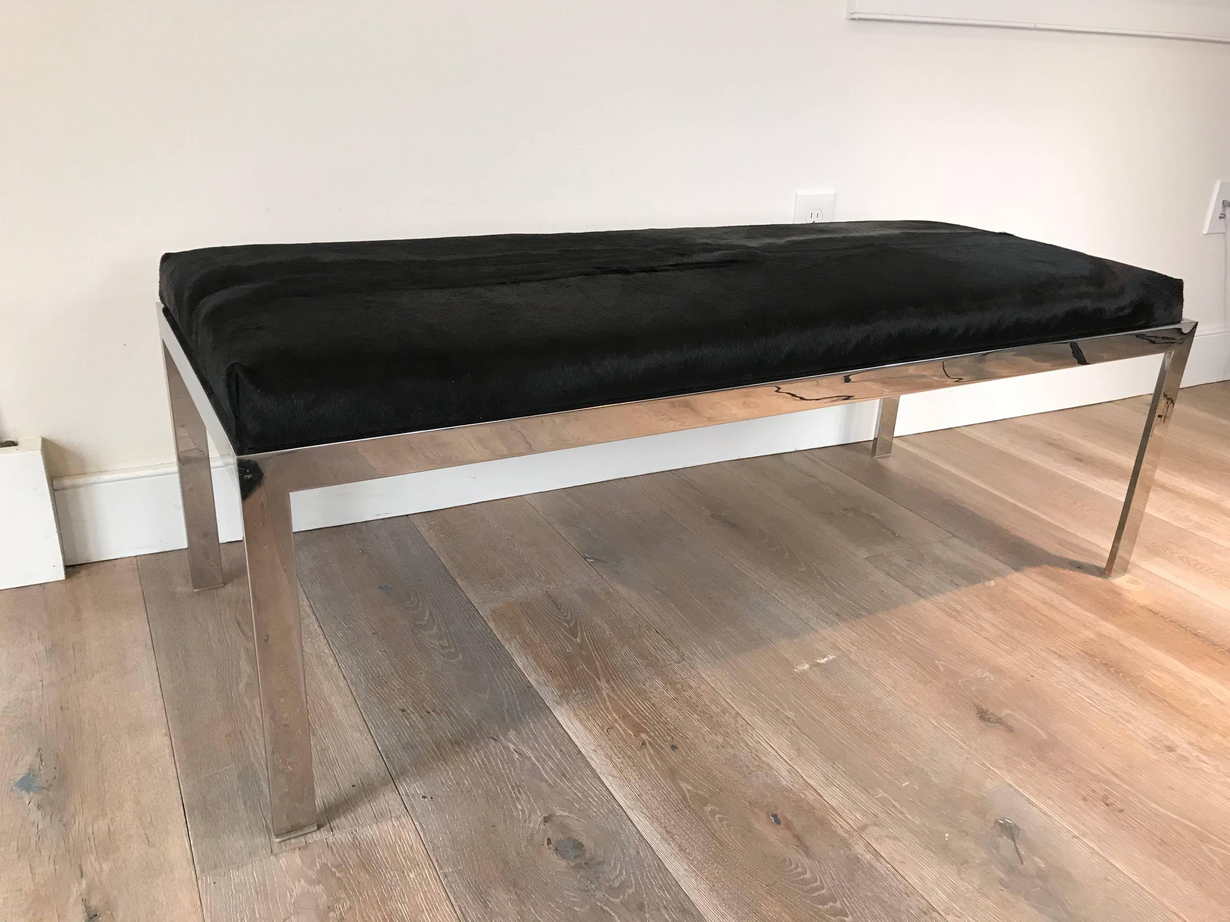 A Milo Baughman chrome bench with jet black cowhide upholstery.