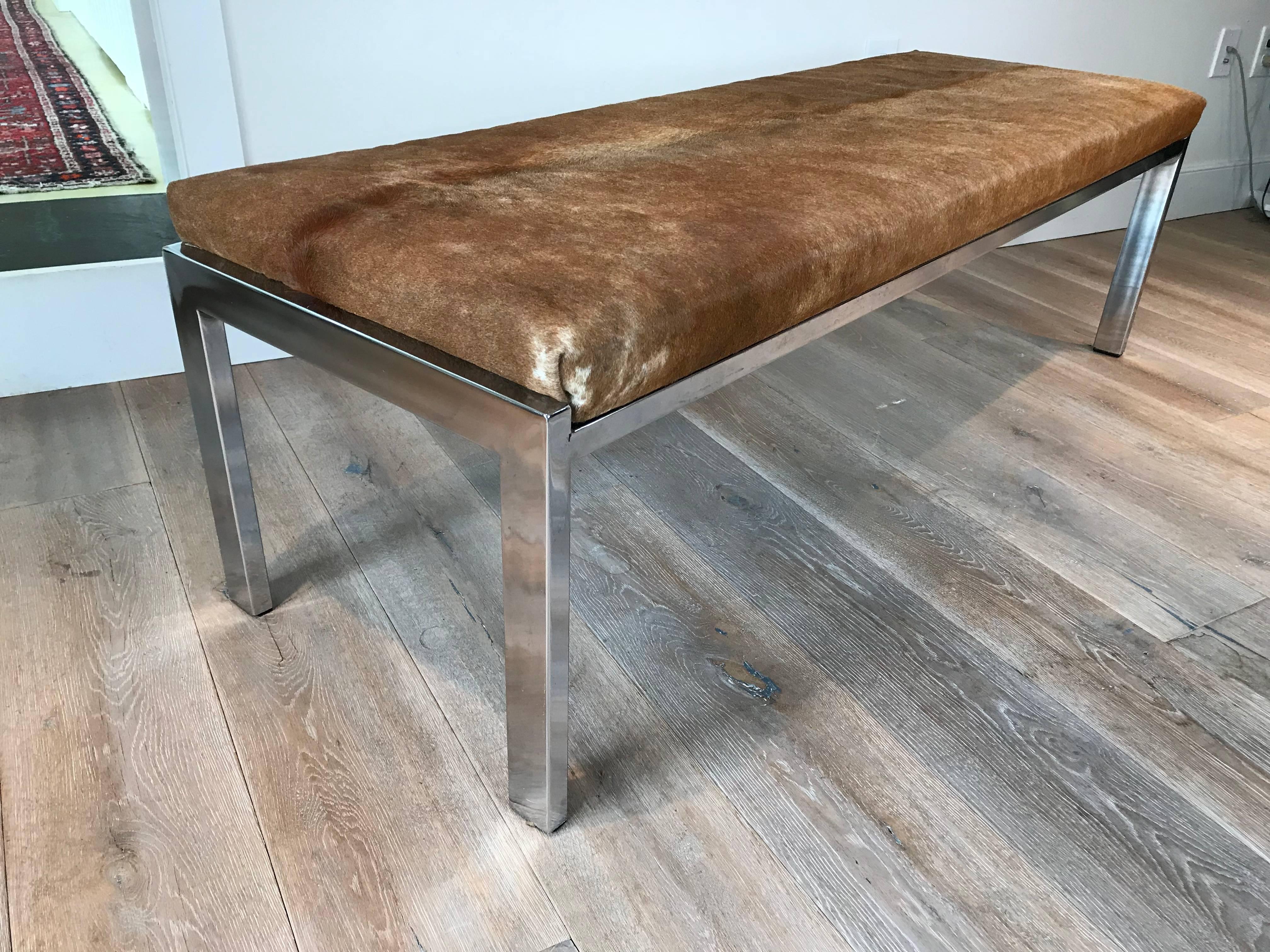 A long chrome bench with tan cowhide upholstery by Milo Baughman.