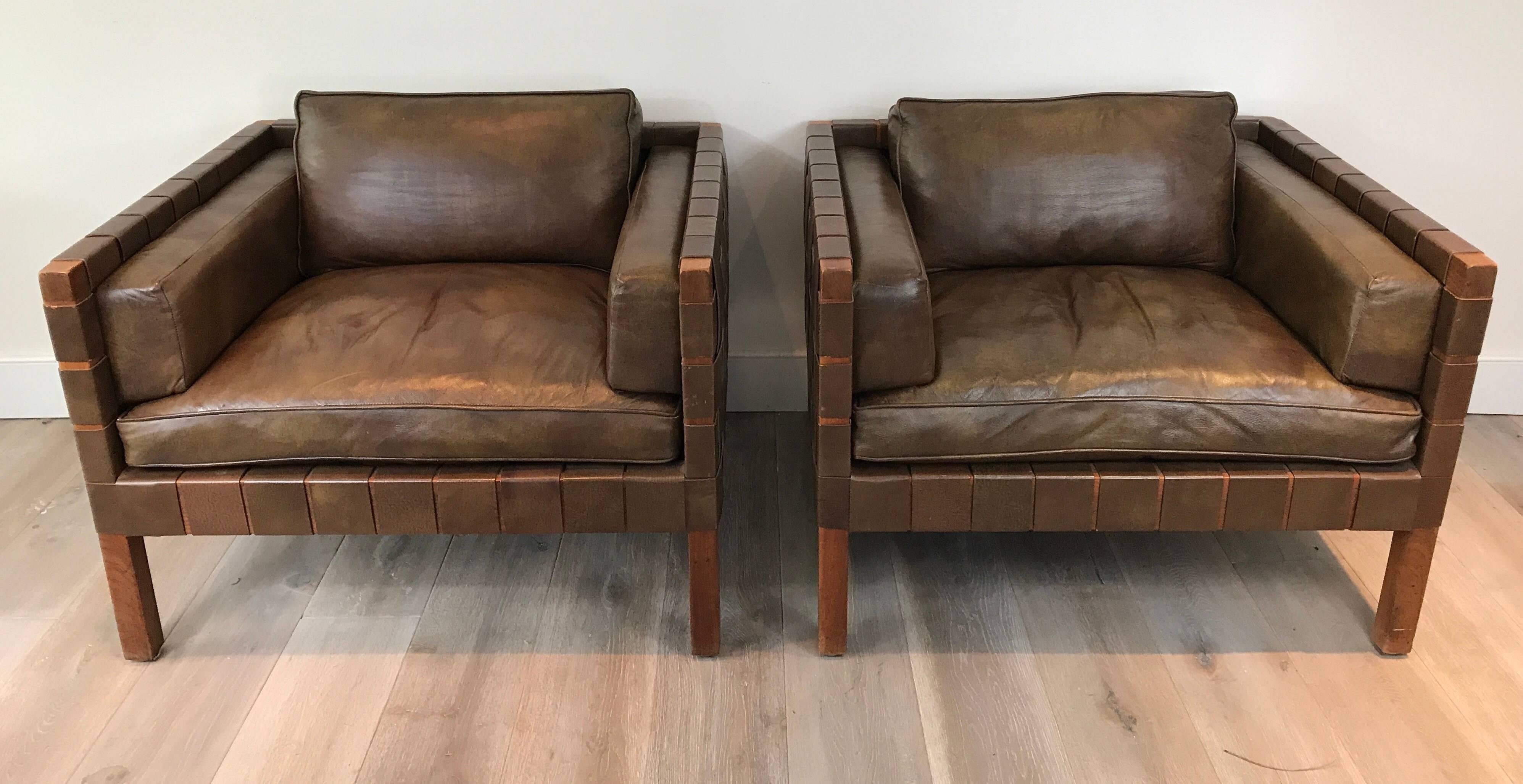 Stunning pair of Danish club chairs with rich brown leather seats and woven leather frame. Large-scale and great proportions.