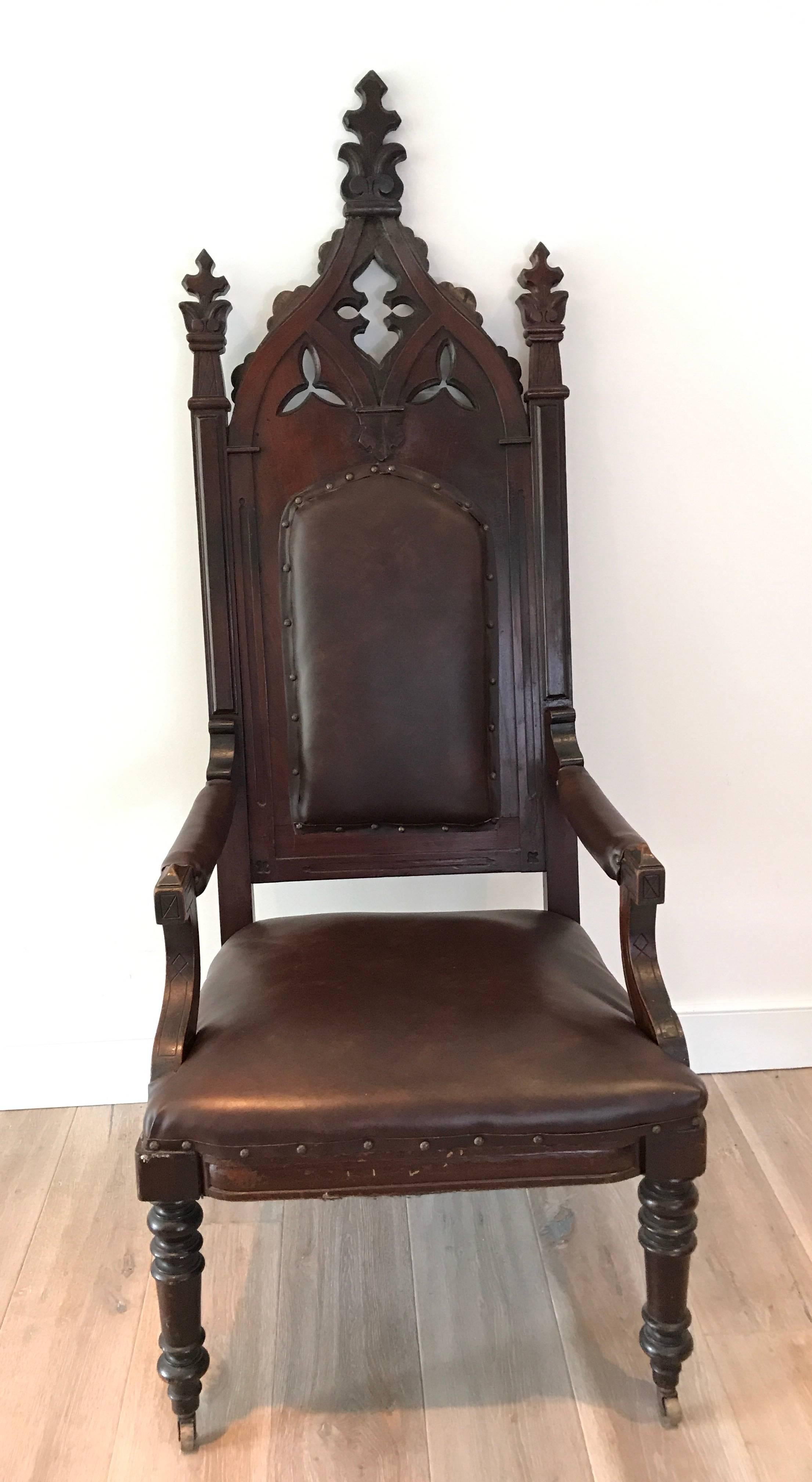 Heavily carved oak 19th century English Gothic Revival armchair with leather upholstery. Measures: 26.5