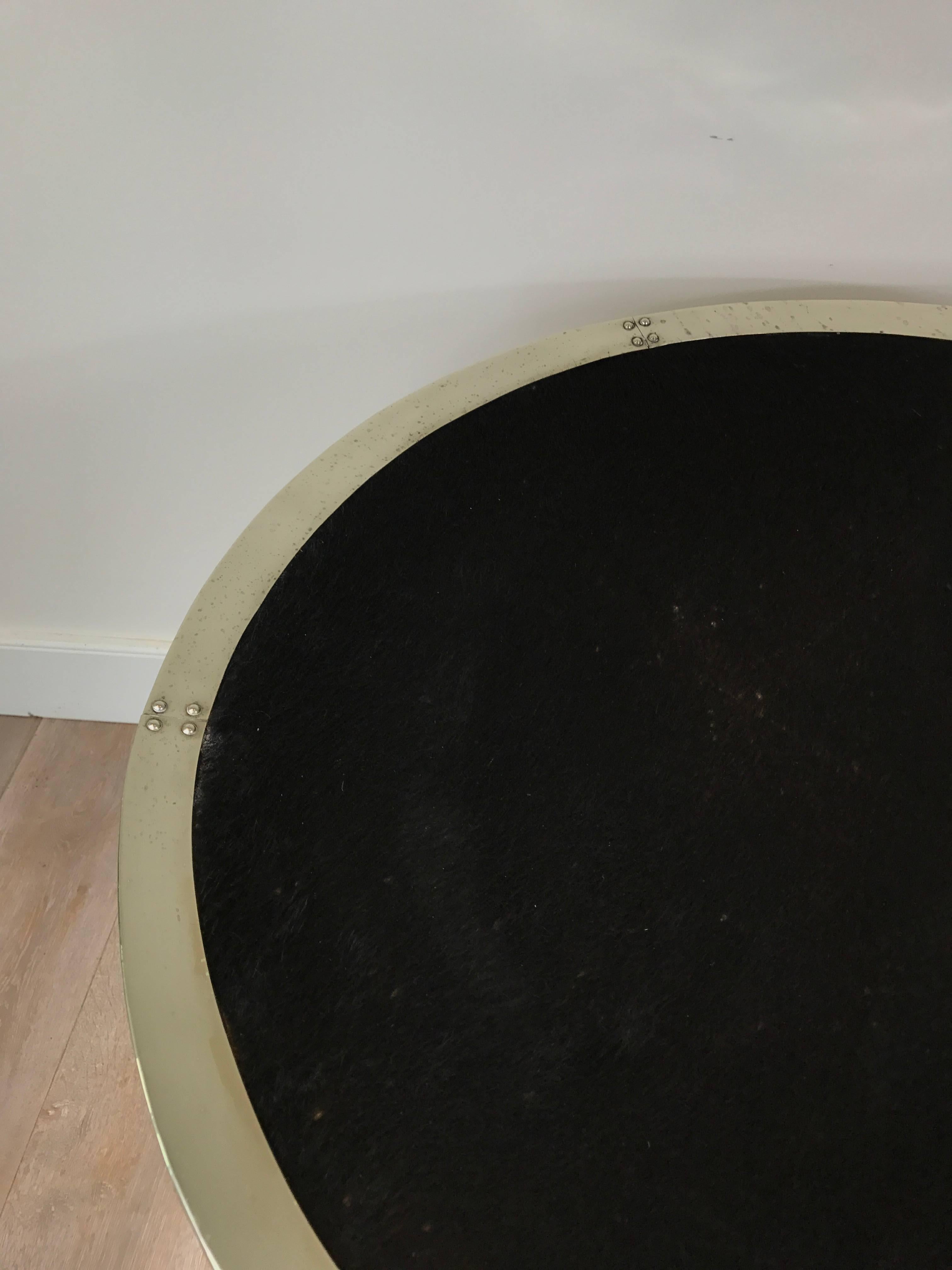 A large black cowhide circular tray with silvered metal surround.