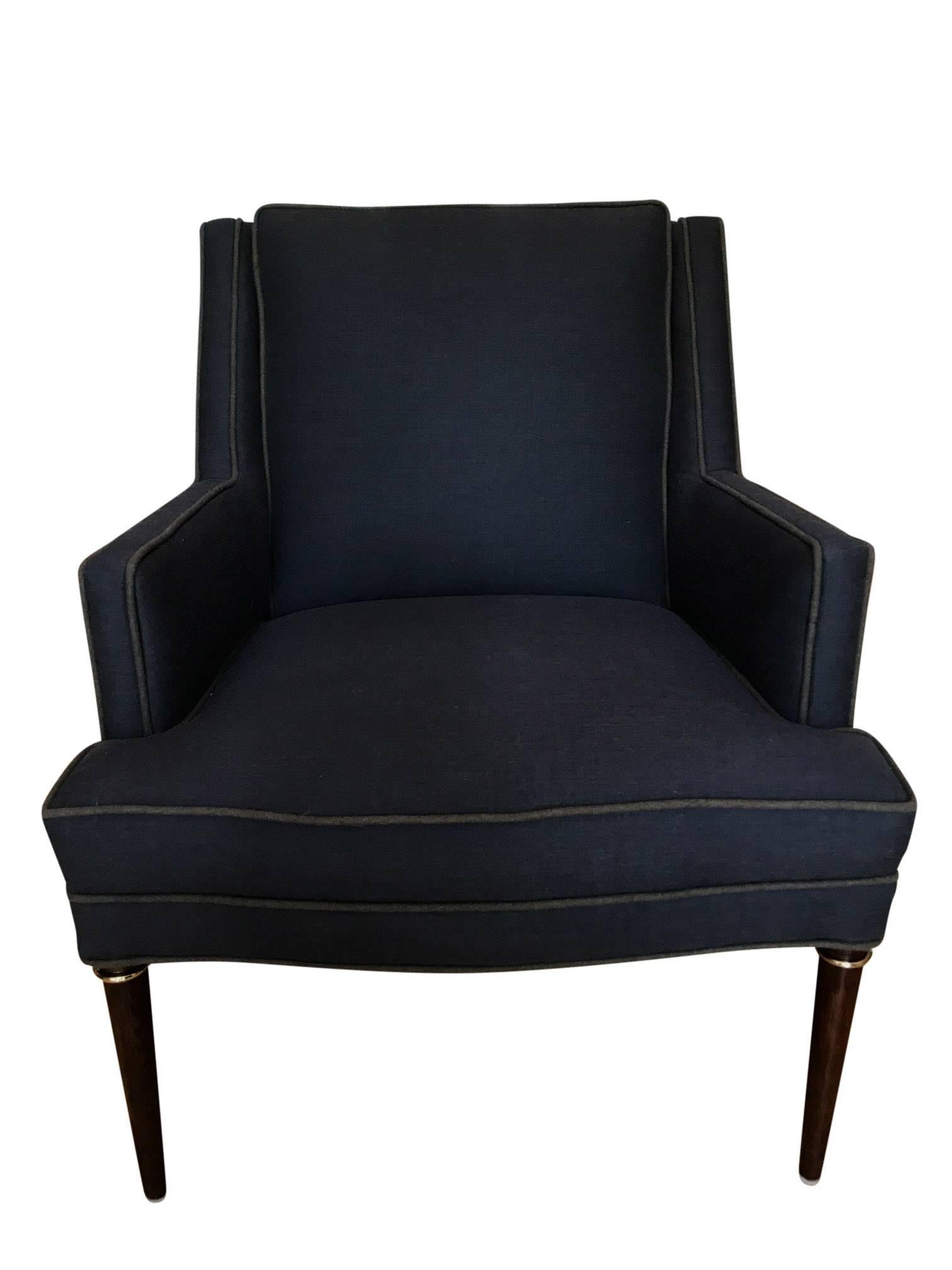 An Edward Wormley for Dunbar armchair. Wonderful structured lines with mahogany legs with brass ring detail. Newley upholstered in grey with contrasting wool piping.