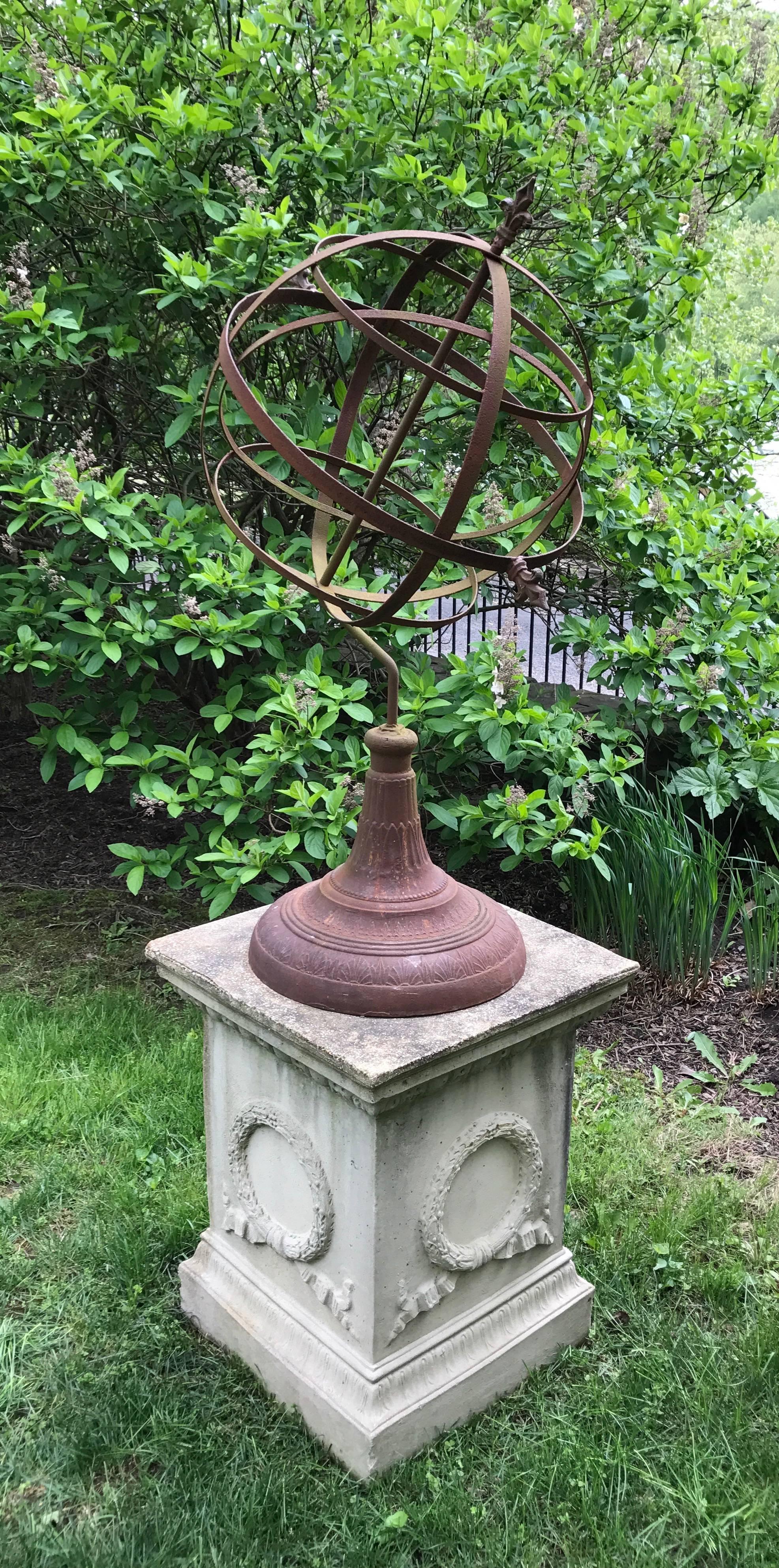 Large and impressive wrought iron armillary on associated laurel motif cast stone pedestal. 
Armillary measures 17" D x 45" H and pedestal measures 23" W x 23" D x 28.5" H.