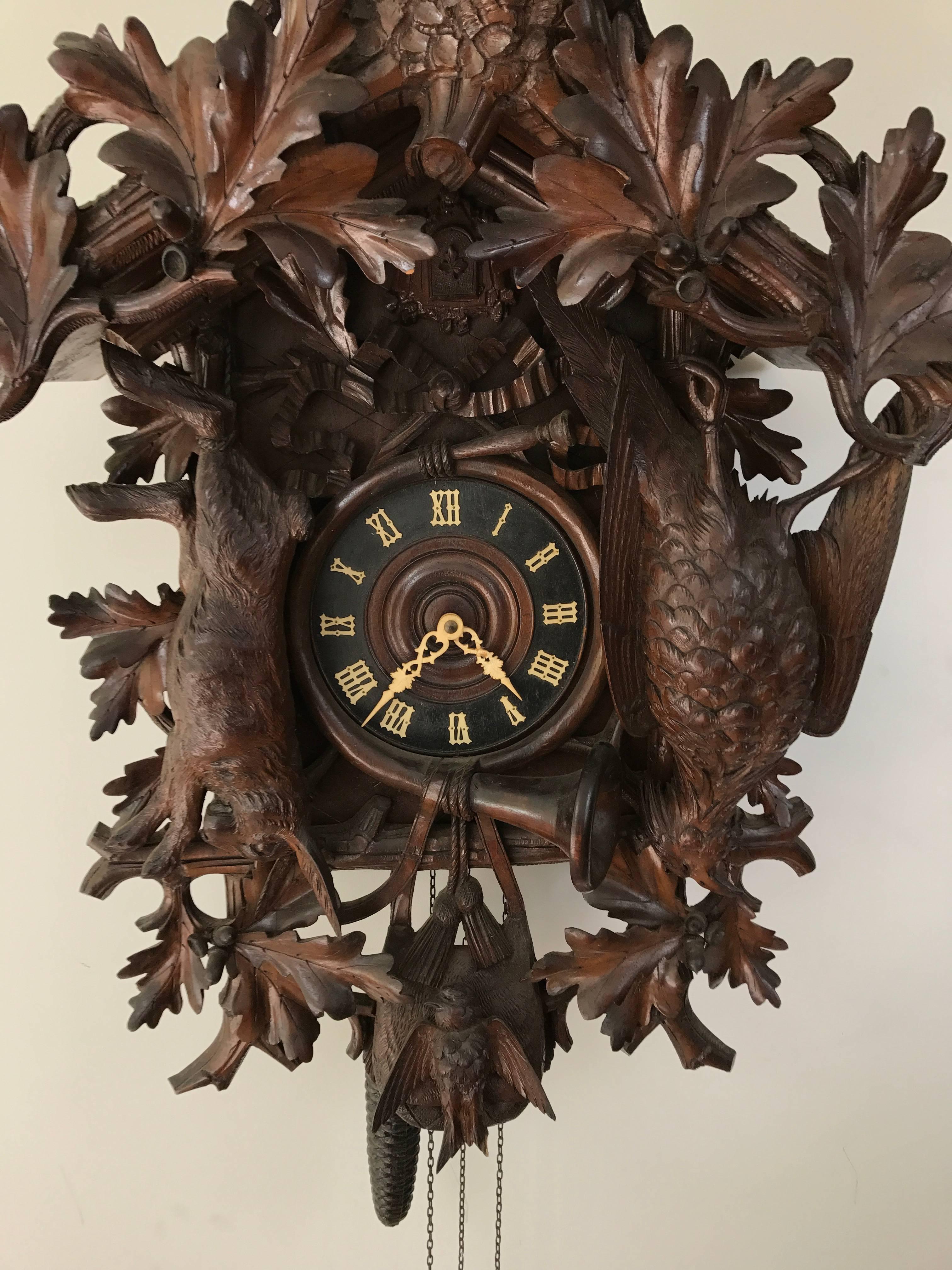 Rare and unusual large-scale Black Forest carved cuckoo clock. Elaborately detailed game decoration topped with an eagle.