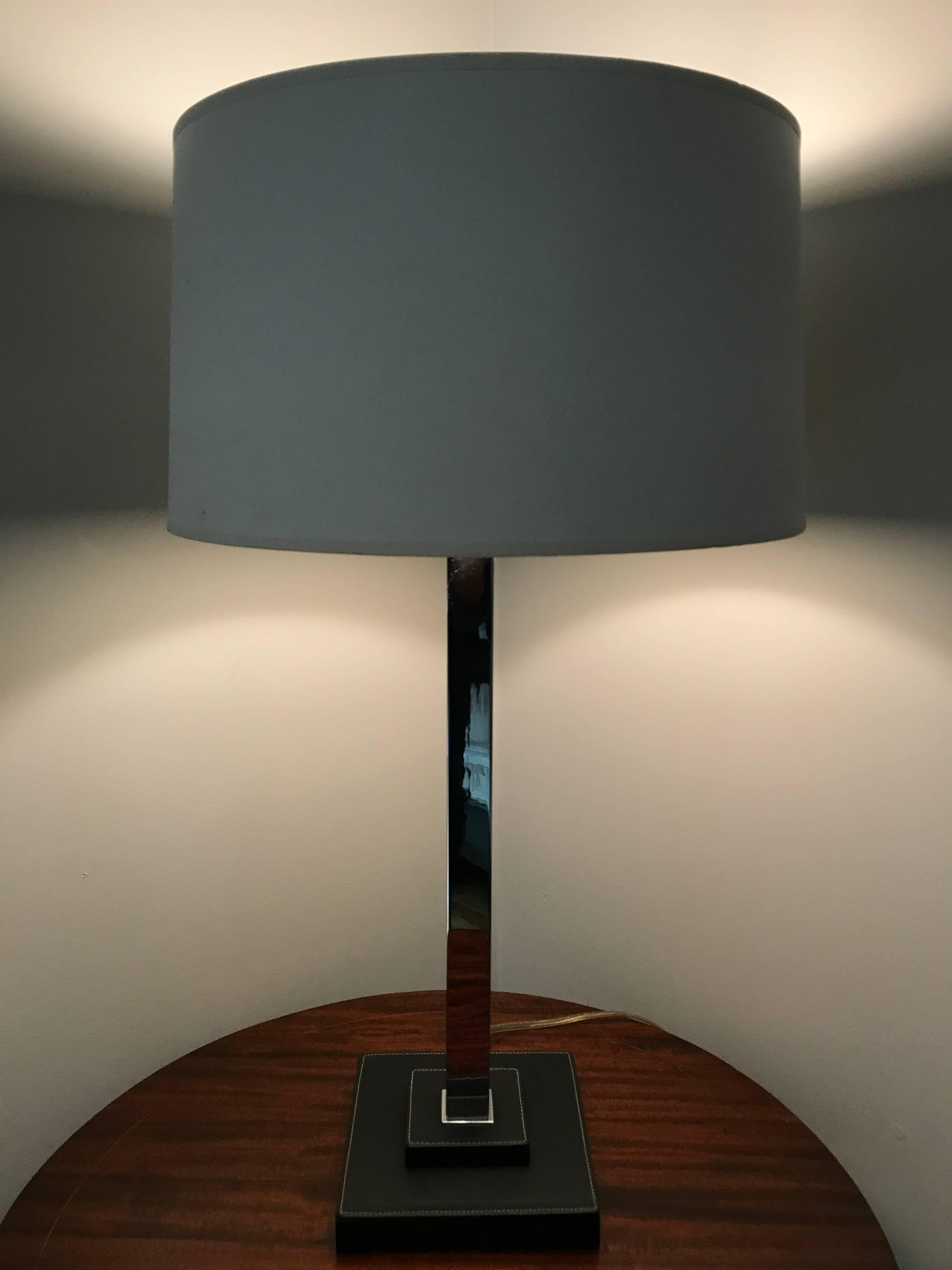 Pair of Nessen Studios table lamps with stitched leather base and chrome body. Shade for display purposes only.