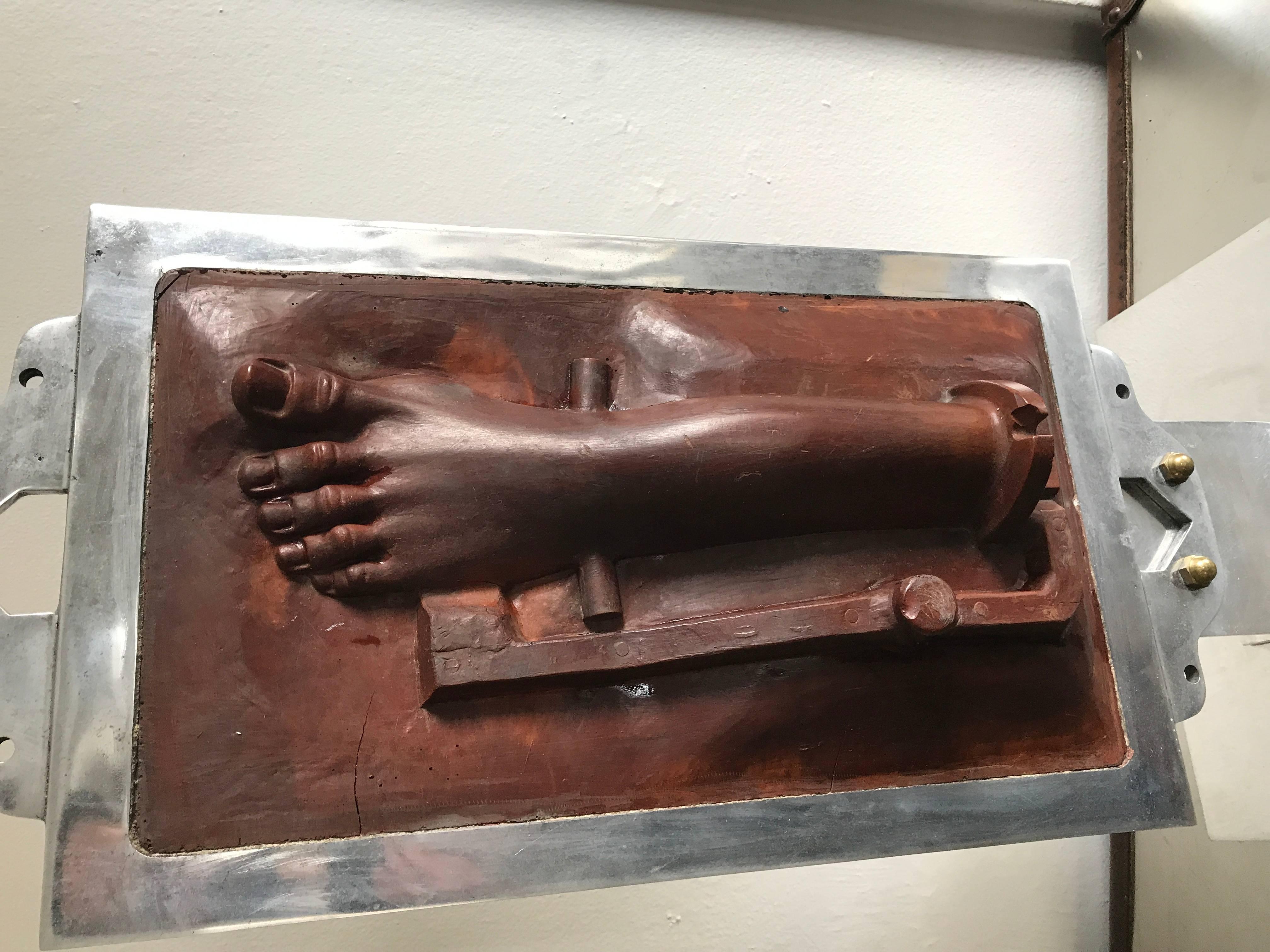 Very interesting terra cotta mold of a foot. By repute used in casting the foot of Jesus on the Crucifix. Displayed in a heavy chrome framed base.