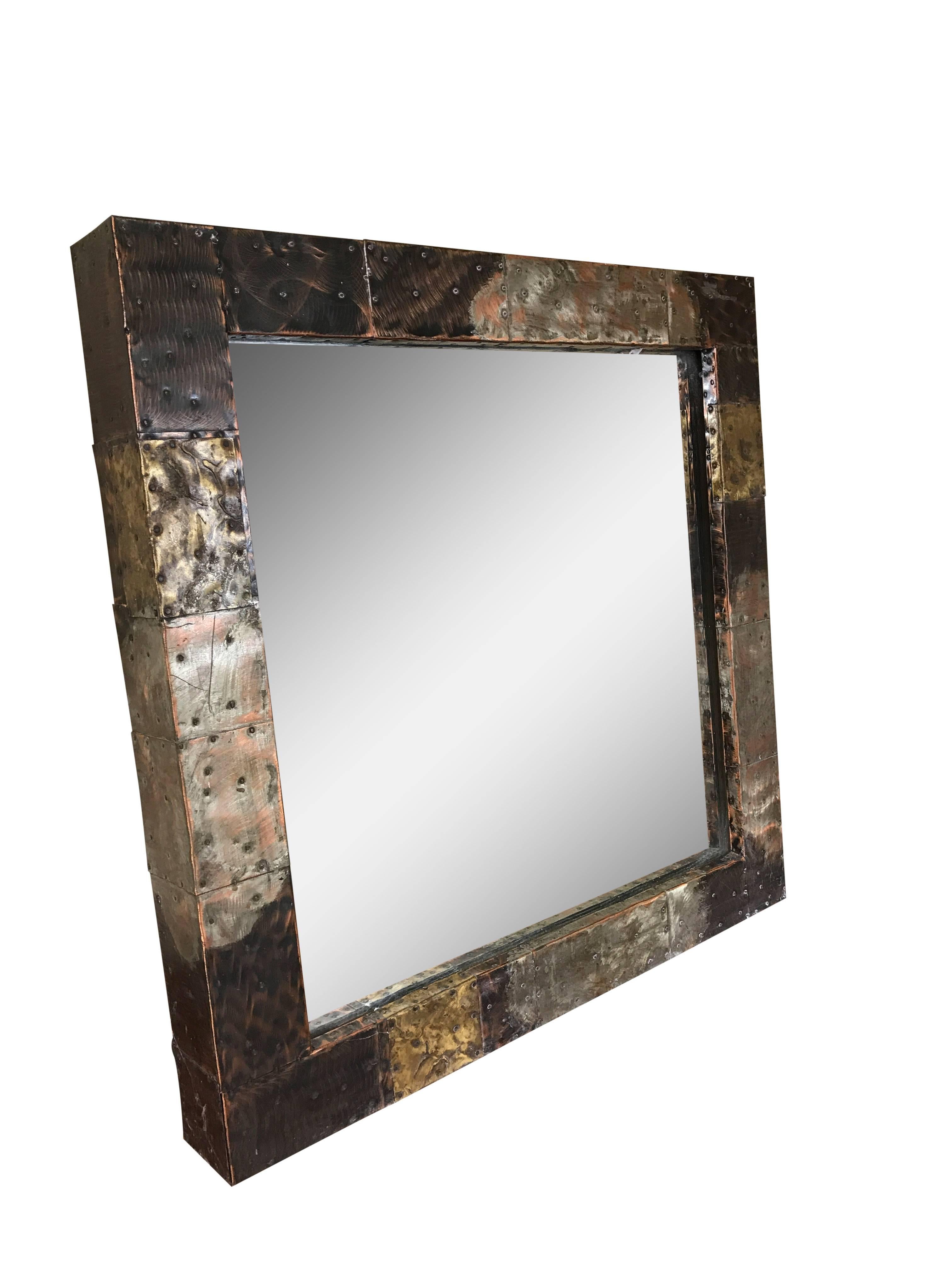 A Paul Evans for Directional wall mirror. Frame comprised of copper, brass and pewter patchwork.
