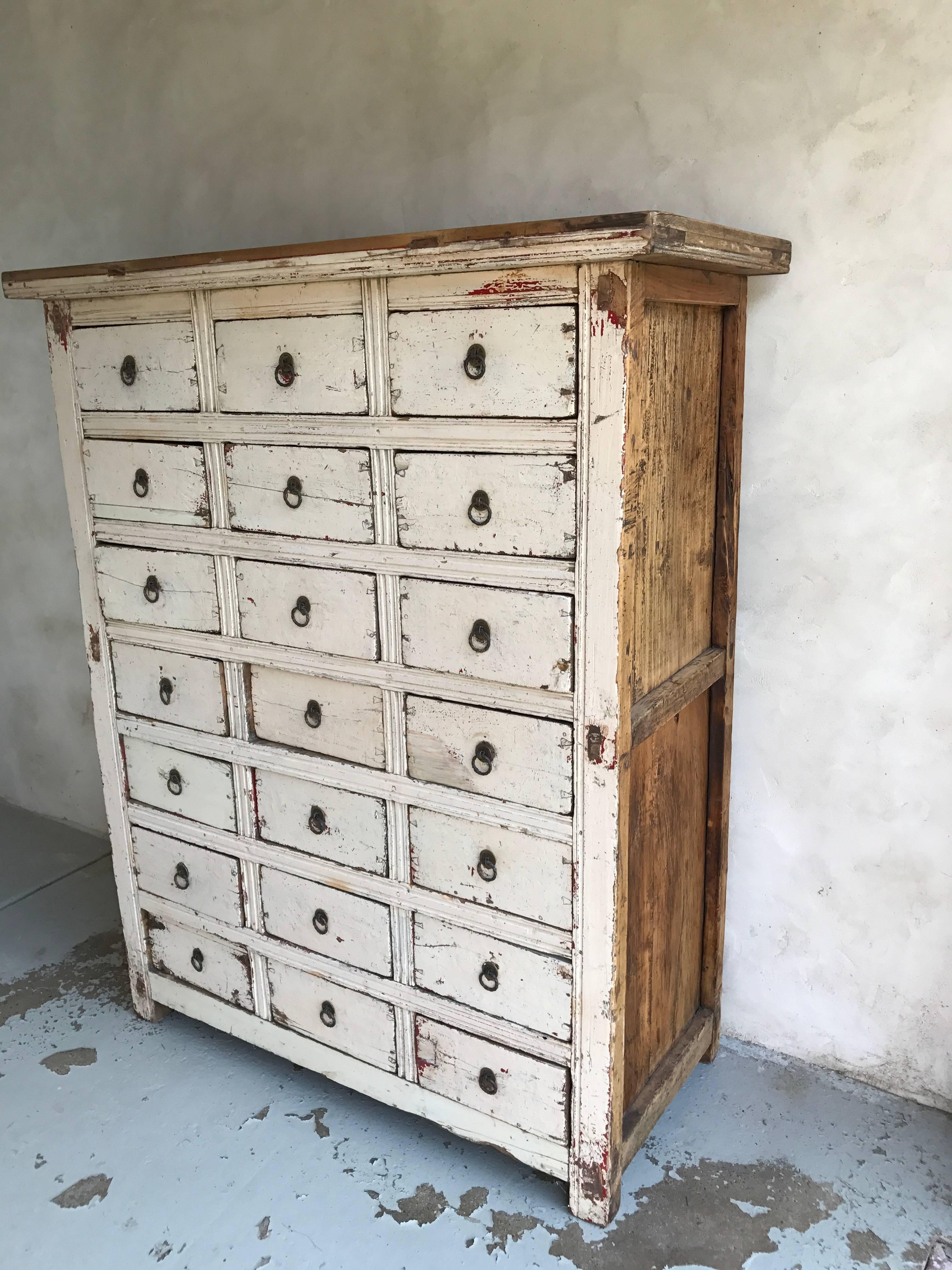 A Primitive distress painted cabinet with 21 drawers. Solid and heavy construction.