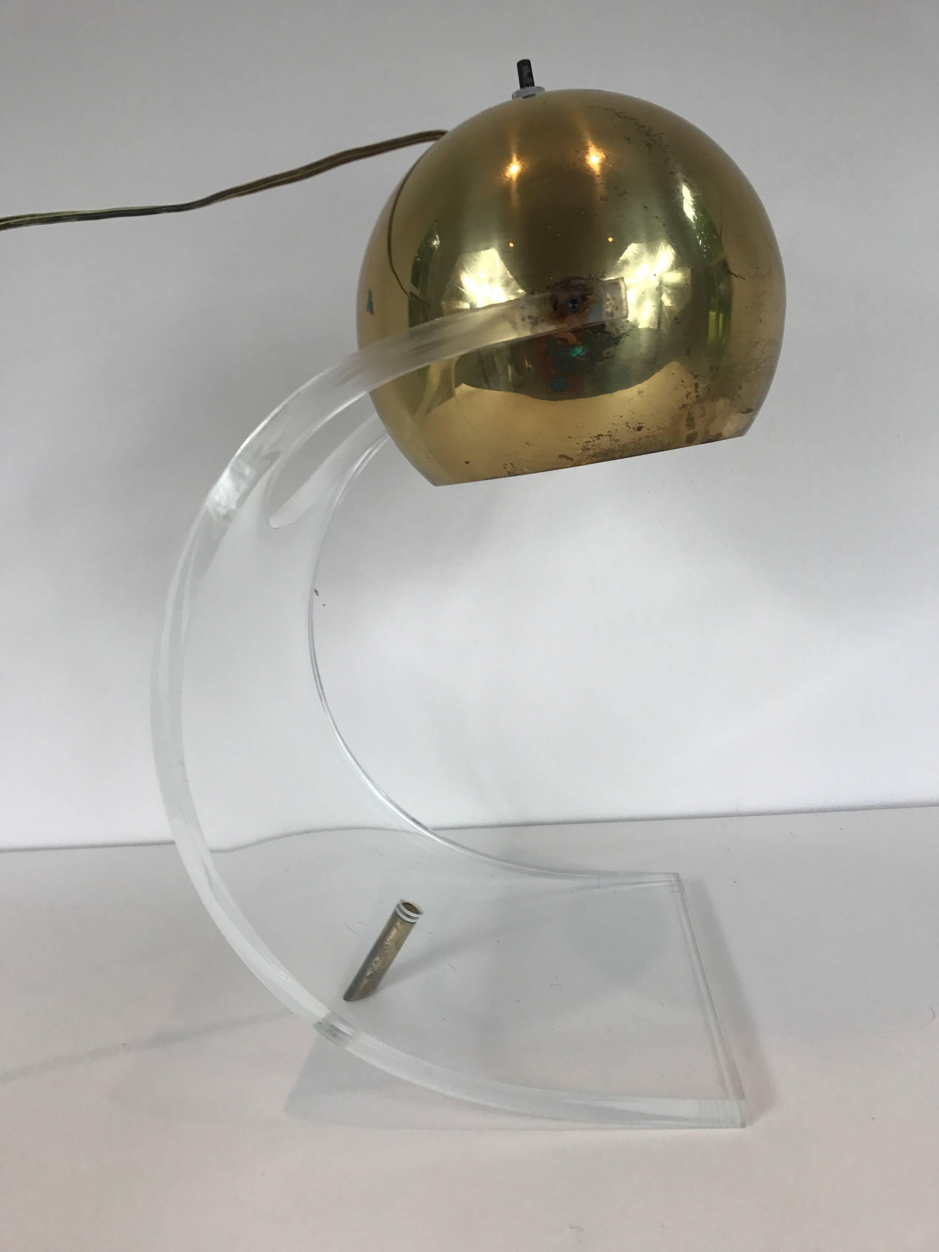 A Robert Sonneman designed desk lamp with adjustable brass shade and curved Lucite base.