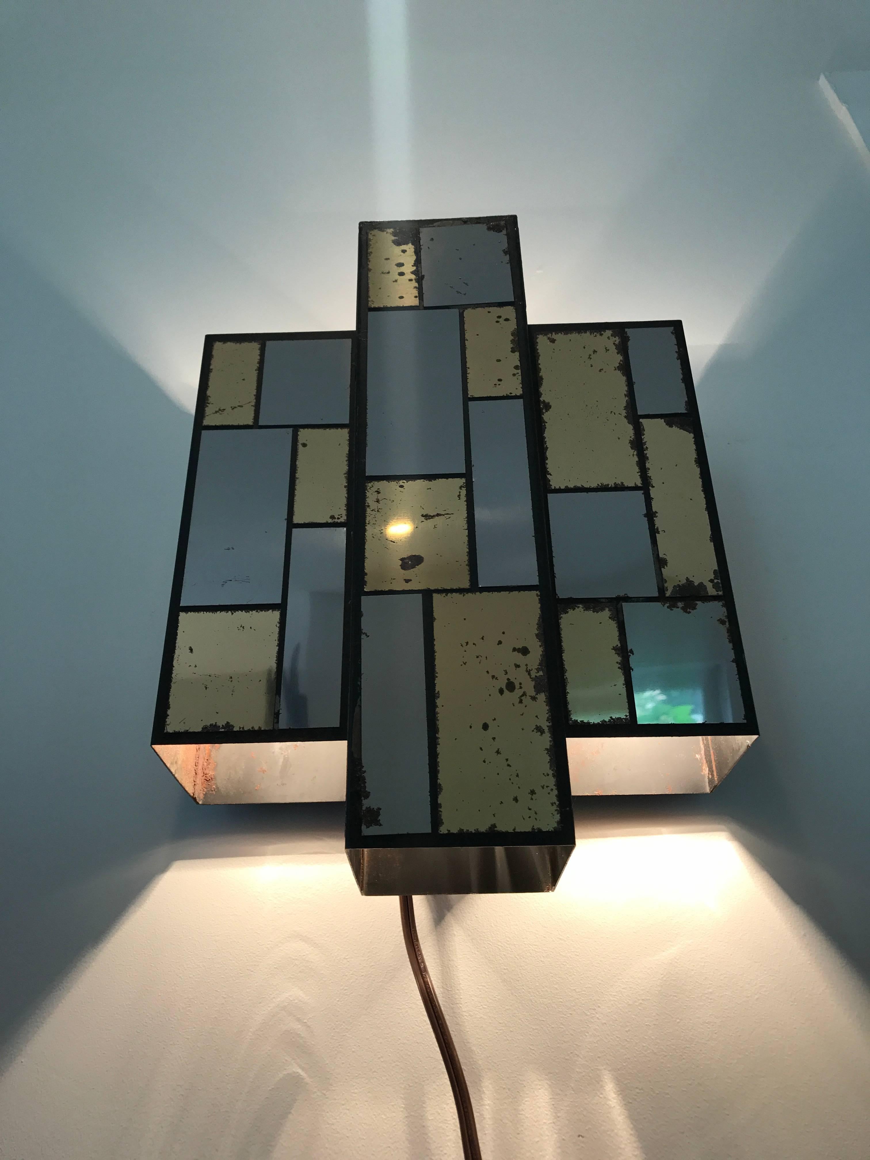 Wonderful and unique sculptural Art Deco patchwork sconce of mirrored chrome and brass. Fixture has six sockets in total, three on top and three on the bottom. Great vintage patina throughout.