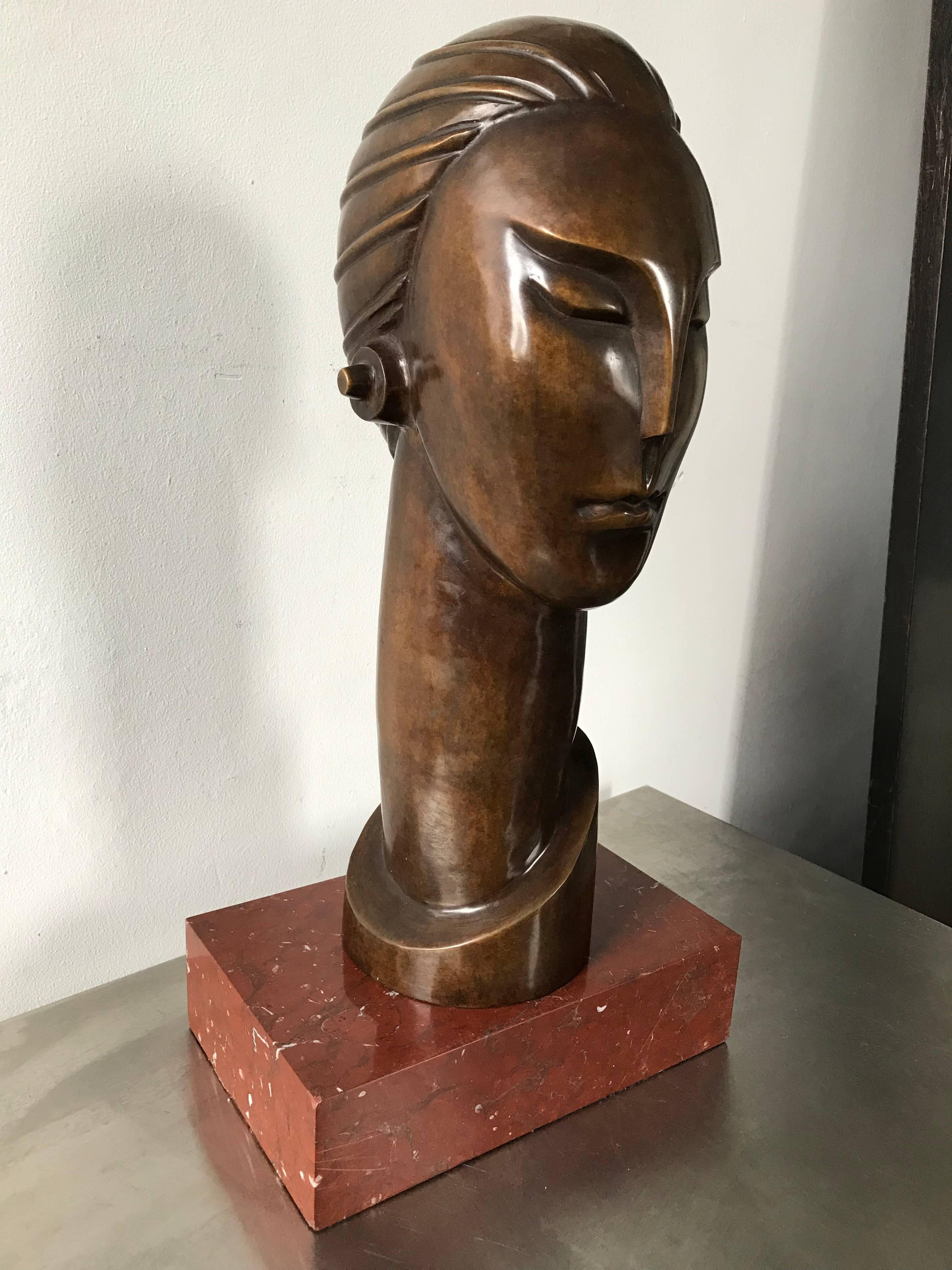 A fine Art Deco bronze bust after works by period artists Gustave Miklos, Joseph Csaky, and Constantin Brancusi. Futuristic or machine age qualities. Displayed on a red marble base. Unmarked.
Bust without base measures 16.5