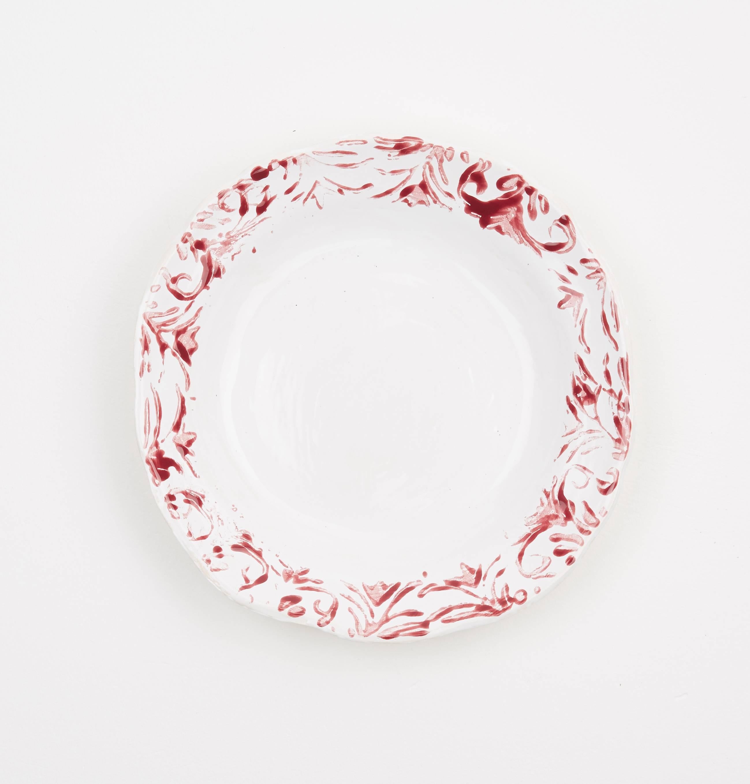 Hand printed red and white dessert plates, set of four. 

These ceramic plates are handmade and hand-painted by Zsuzsanna Nyul in Gloucestershire. They are high fired stoneware pieces with different designs created using an unique technique. The