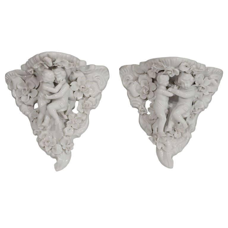 Two Porcelain Wall Shelves with Affectionate Cherubs For Sale