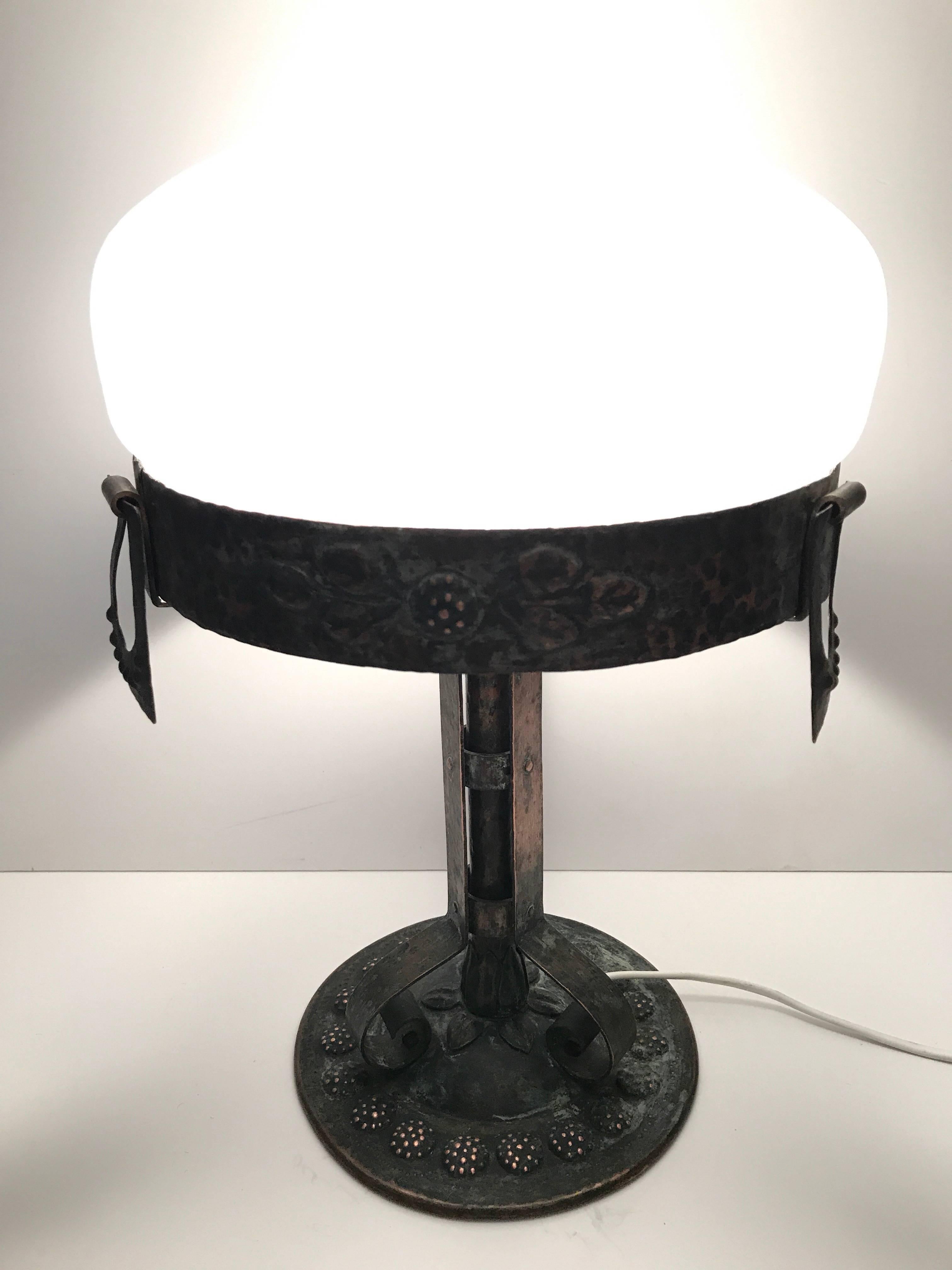 1915 Swedish Art Nouveau Jugendstil copper and frosted glass table lamp.
A beautiful copper table lamp decorated with flowers along the rim and the base. The beautifully frosted glass shade with a crackle pattern was most likely made at Pukeberg