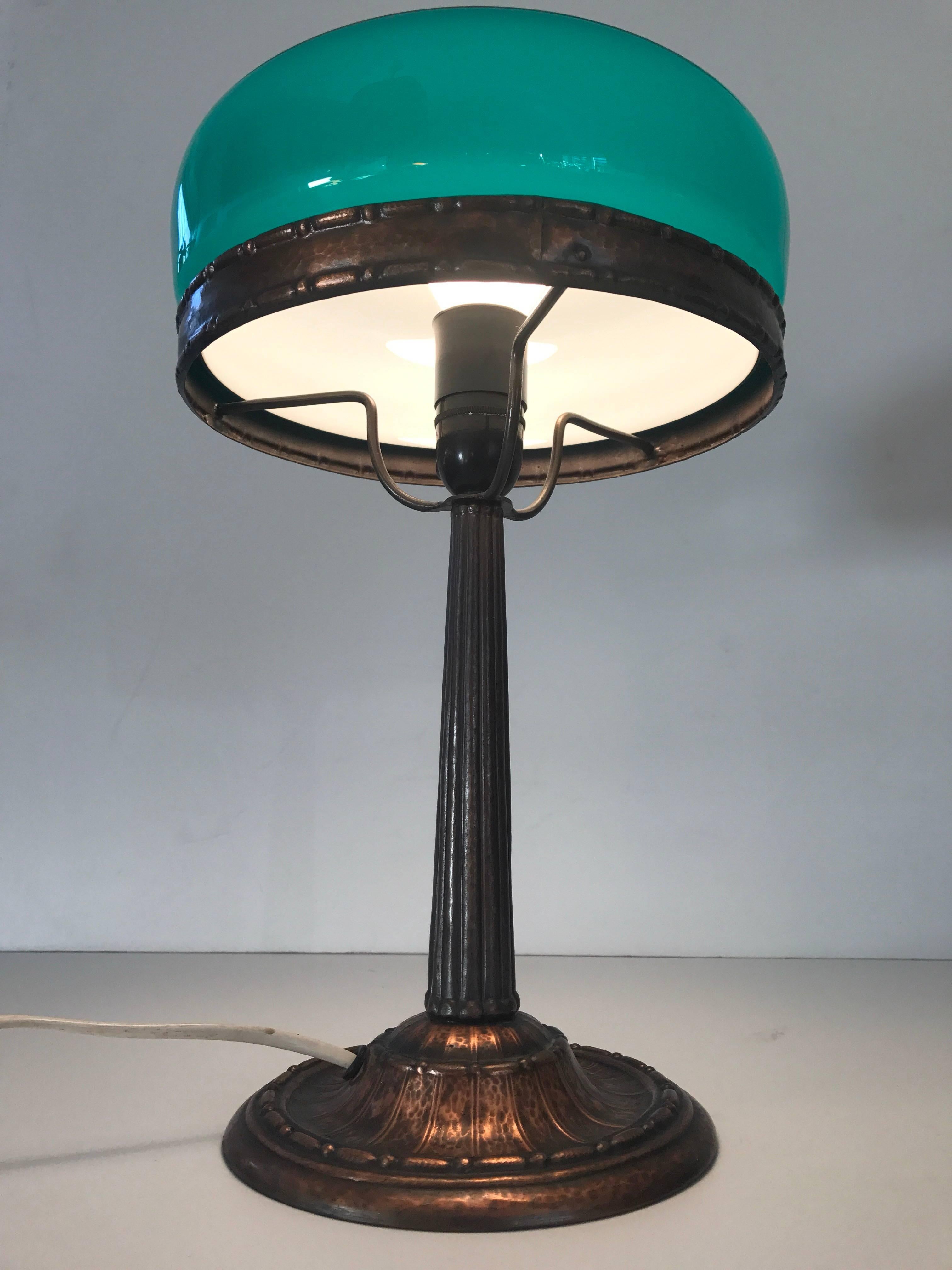 Swedish Art Nouveau Jugendstil 1920 copper and glass table lamp. A beautiful dark green blown glass shade most likely made at Pukeberg or Orrefors glass factory in the early 20th century. The copper has a very nice pattern and is of very high