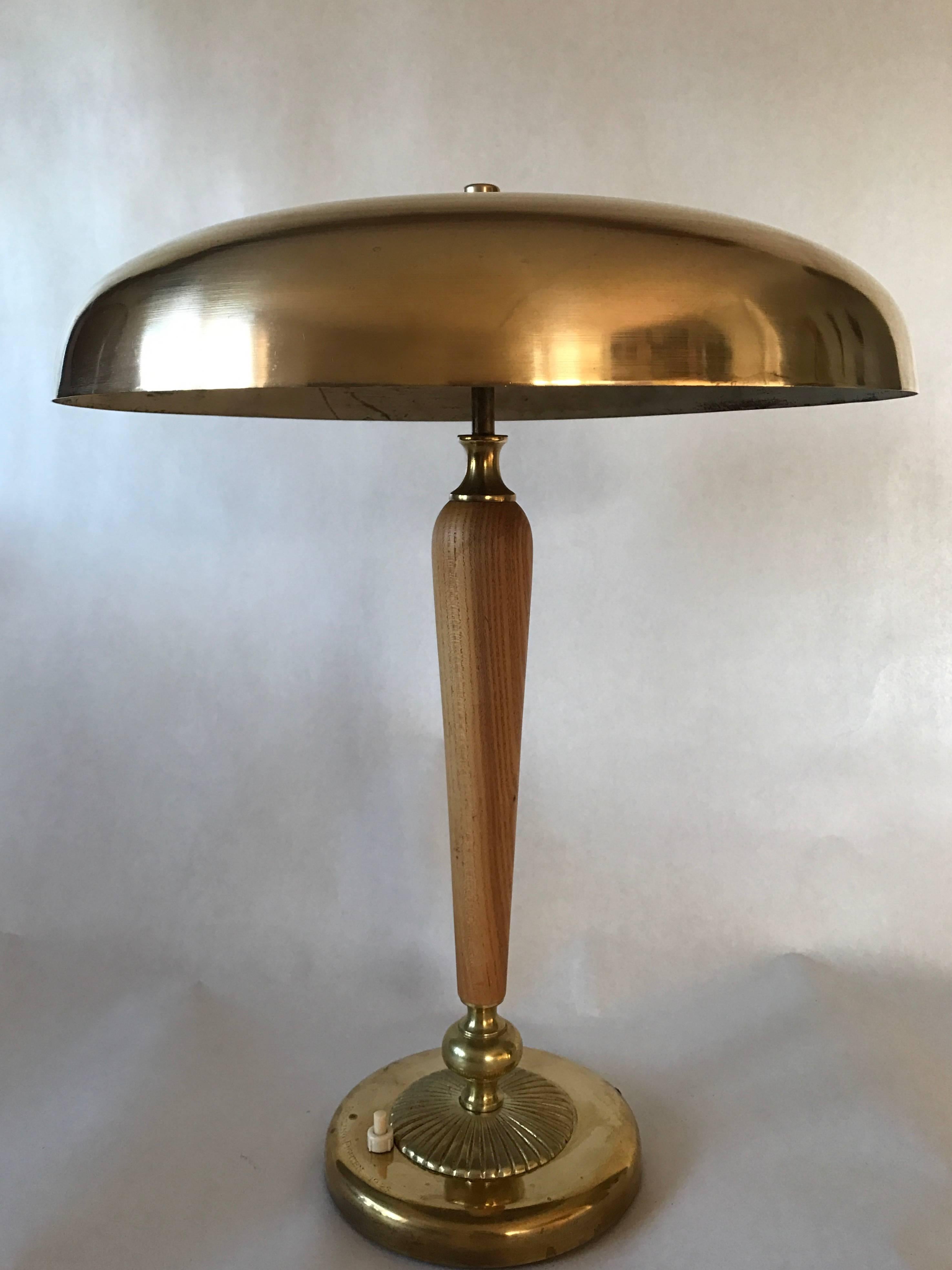 A very nice large Swedish brass table lamp, most likely made circa 1935. The foot is made of beech and brass, all cords has been replaced with new. Measure: The height is 50cm and the diameter of the shade is 40cm. It has some minor bumps and dents,