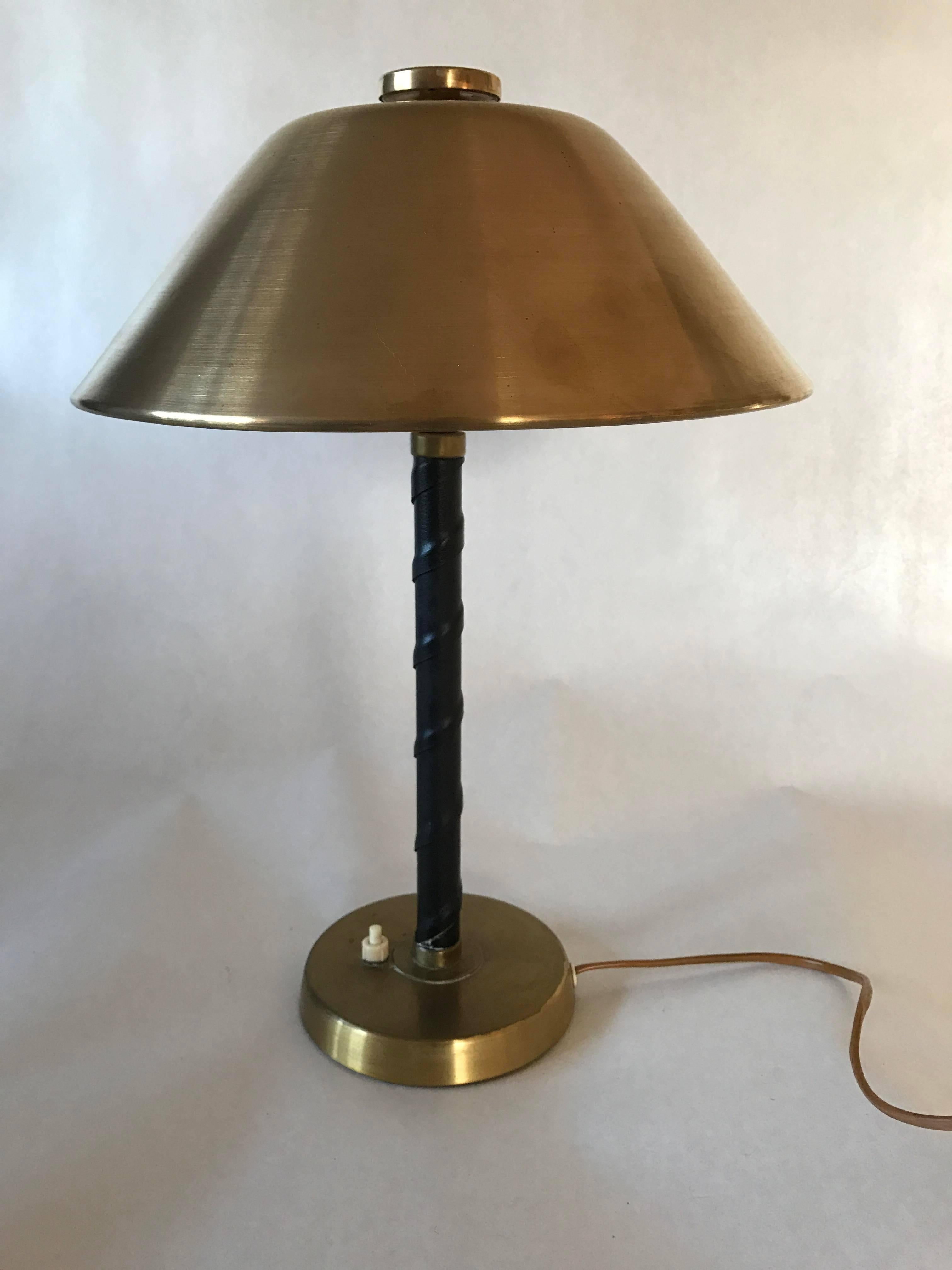 A very beautiful table lamp made by the Swedish lamp manufacturer Einar Bäckström, the foot is made of brass and dark brown leather, the shade is made of brass. The lamp has been rewired with brand new cords. Measures: The height is 42cm and the