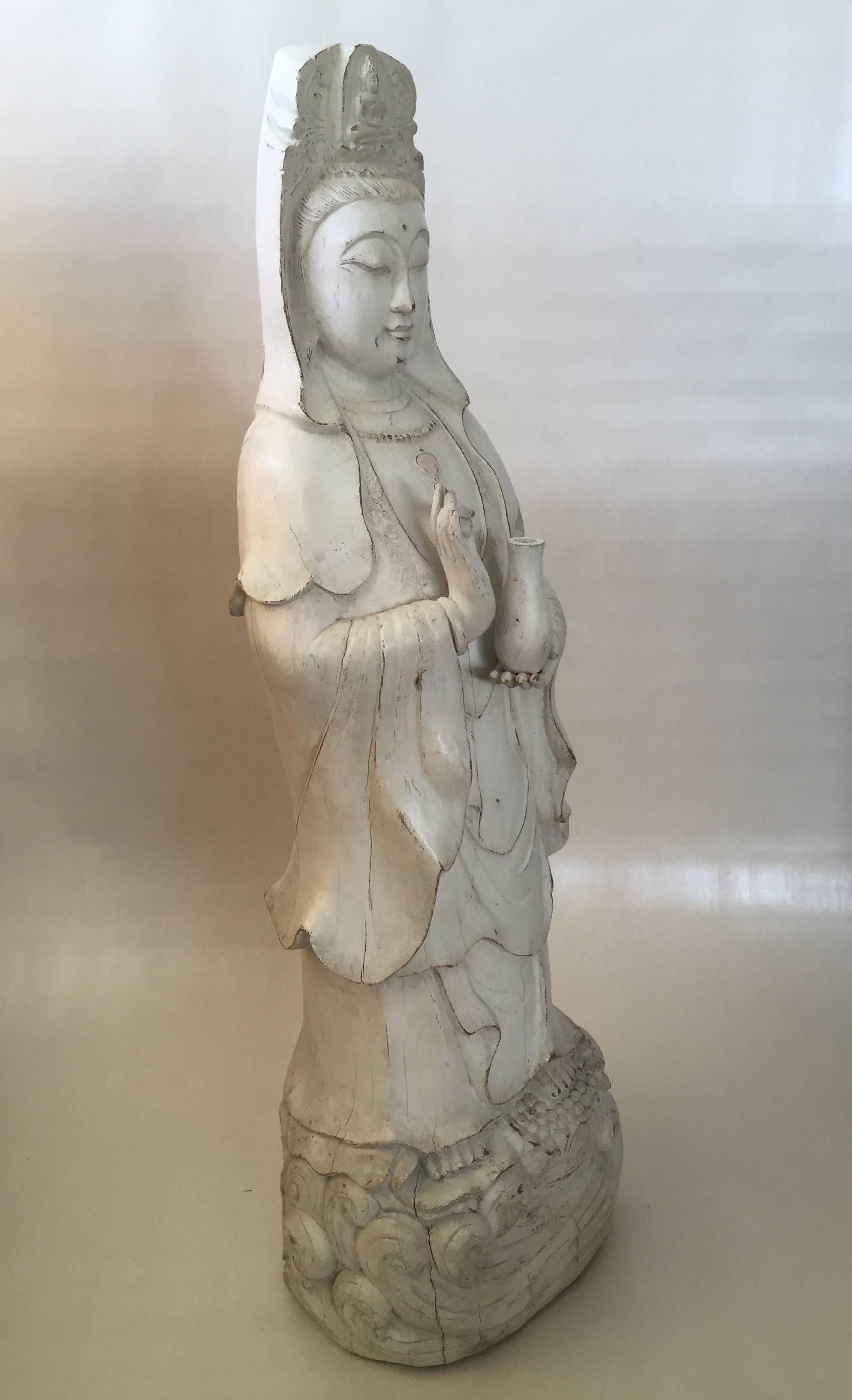 Very Large 19th-Early 20th Century Chinese Wooden Guanyin.
A beautiful Chinese wooden Guanyin in a standing mudra holding a bottle in her left hand, standing on lotus flowers among waves of water. It's a very heavy and large wooden statue and she is